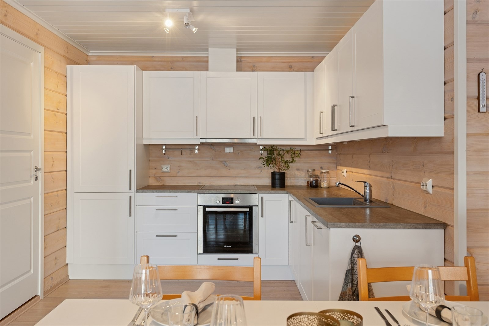 Kjøkkeninnredningen har profilerte hvite fronter med en benkeplate i laminat. Galleribilde