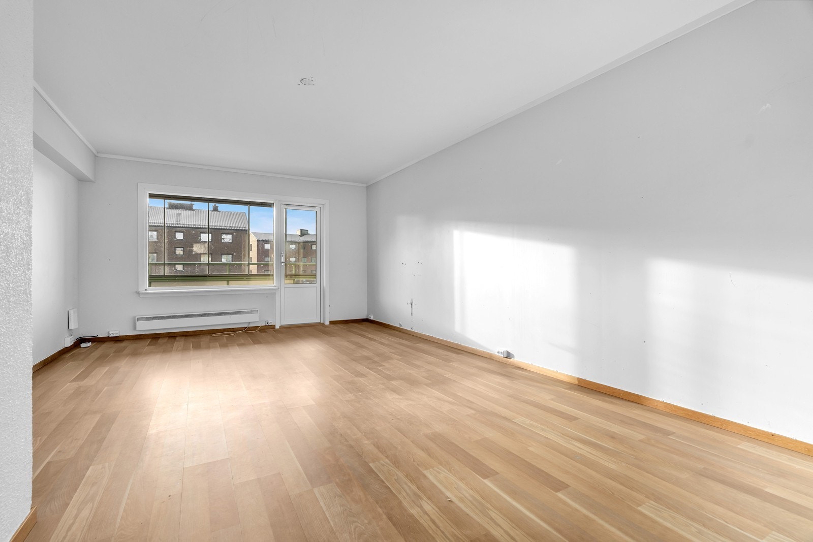 Leiligheten har en lys og luftig stue med store vindusflater som gir rikelig med naturlig lys Galleribilde