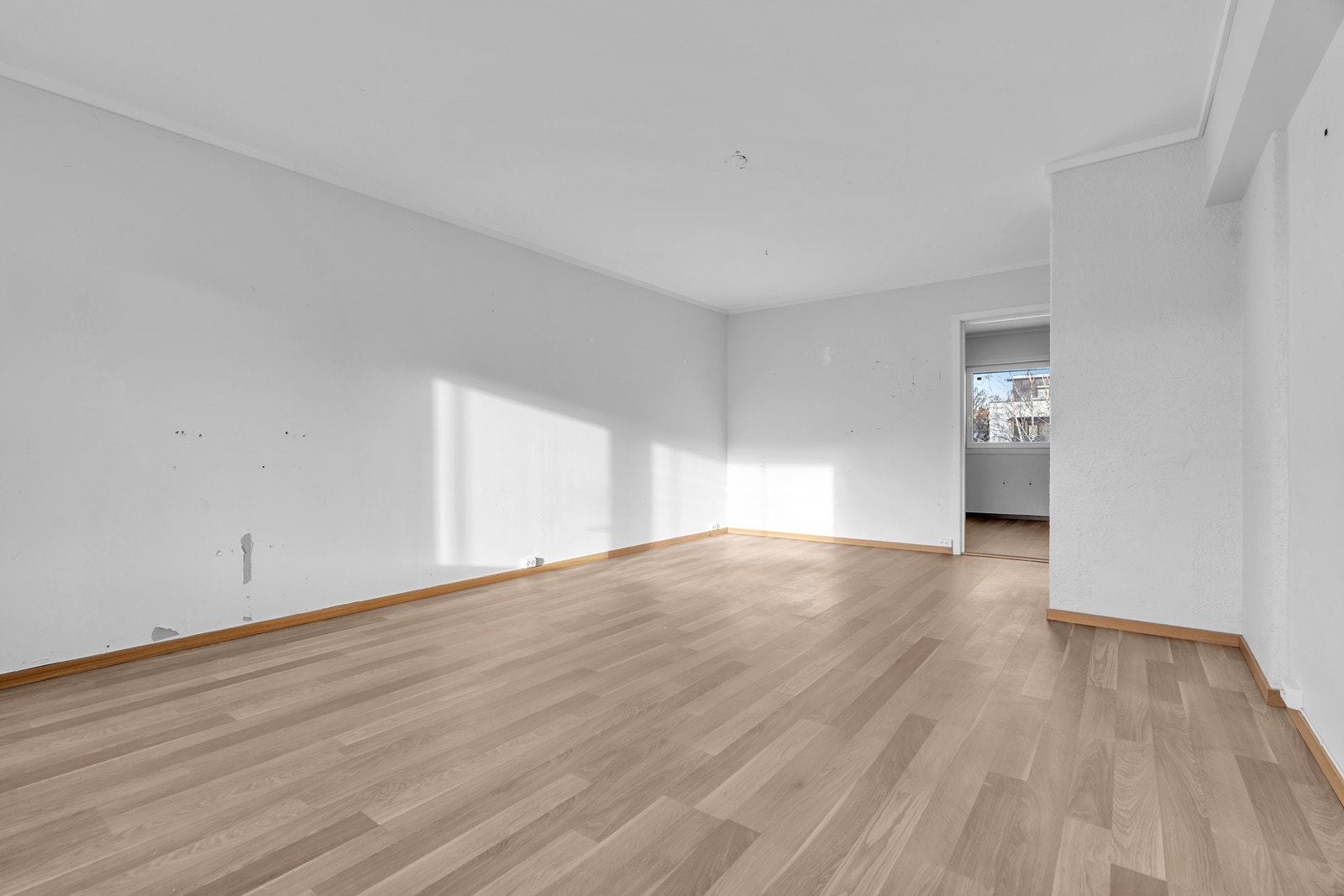 Det er malte sletter vegger og laminat på gulv i stue Galleribilde