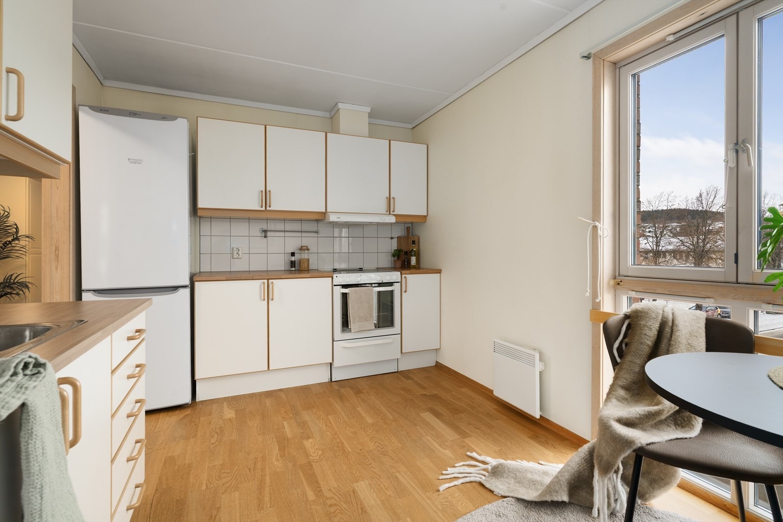 Flis på vegg over benkeplater i laminat, med gode arbeidsflater og nedfelt, dobbel oppvaskkum i rustfritt stål. Galleribilde