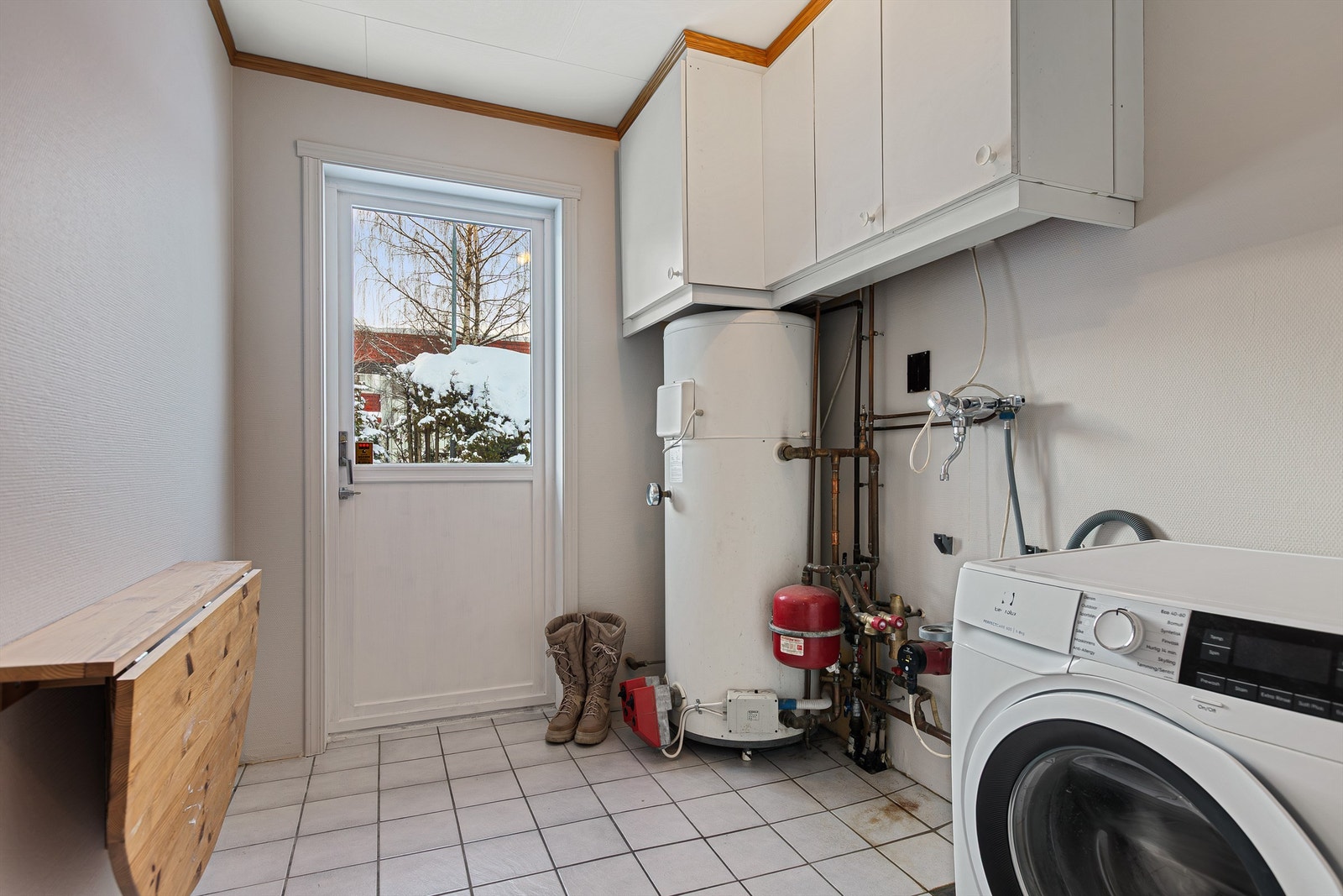 Vaskerommet med opplegg for vaskemaskin. Flislagt gulv med gulvvarme. Galleribilde