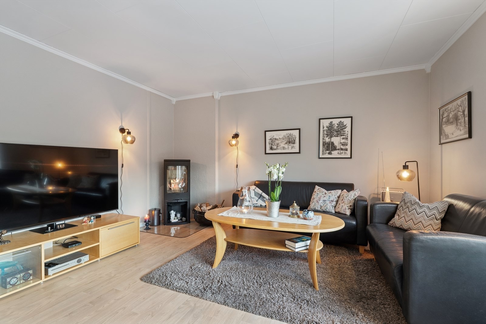 Stuen har naturlige soner for både sofagruppe og spisestue med tilhørende møblement Galleribilde