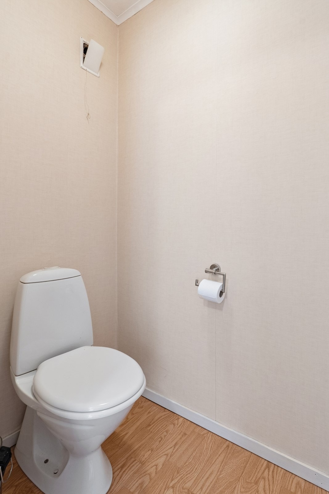 Boligen har et separat toalettrom i andre etasje. Dette rommet har laminat på gulvet, tapet på veggene og malte plater i himlingen Galleribilde