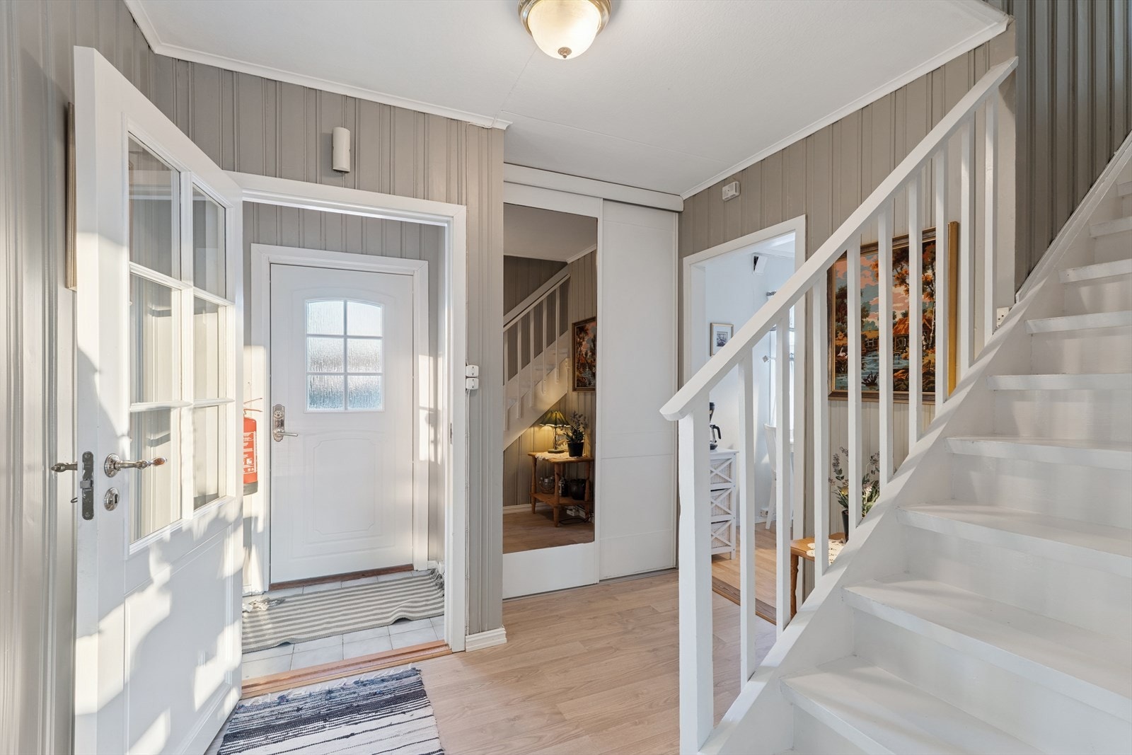 Innenfor døren ønskes du velkommen inn i en romslig entrè med praktisk skyvedørsgarderobe Galleribilde