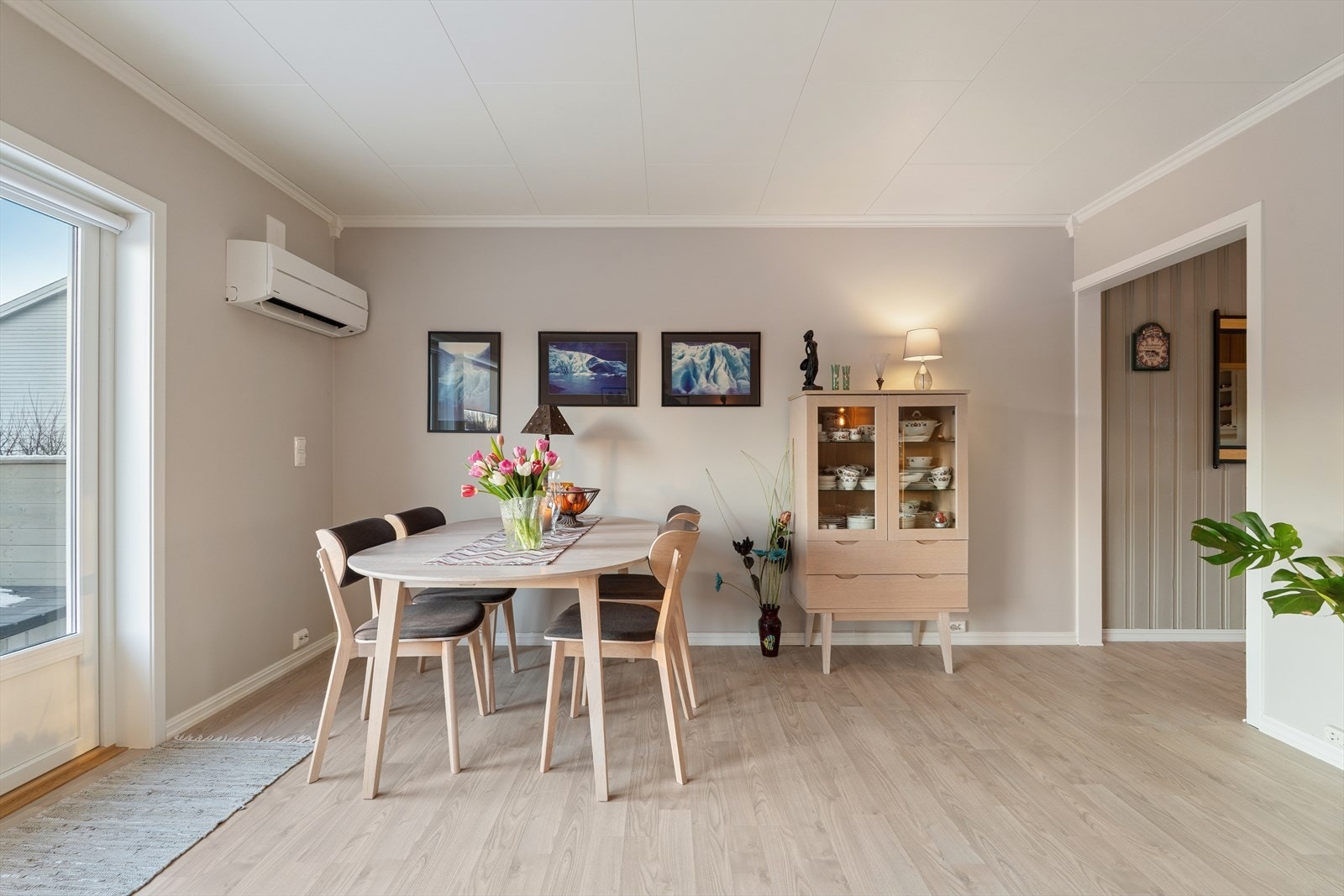 Stuen har laminatgulv, takplater i himlingen og vegger malt i en dus beigetone - en elegant kontrast til de hvite listene og den lyse himlingen Galleribilde