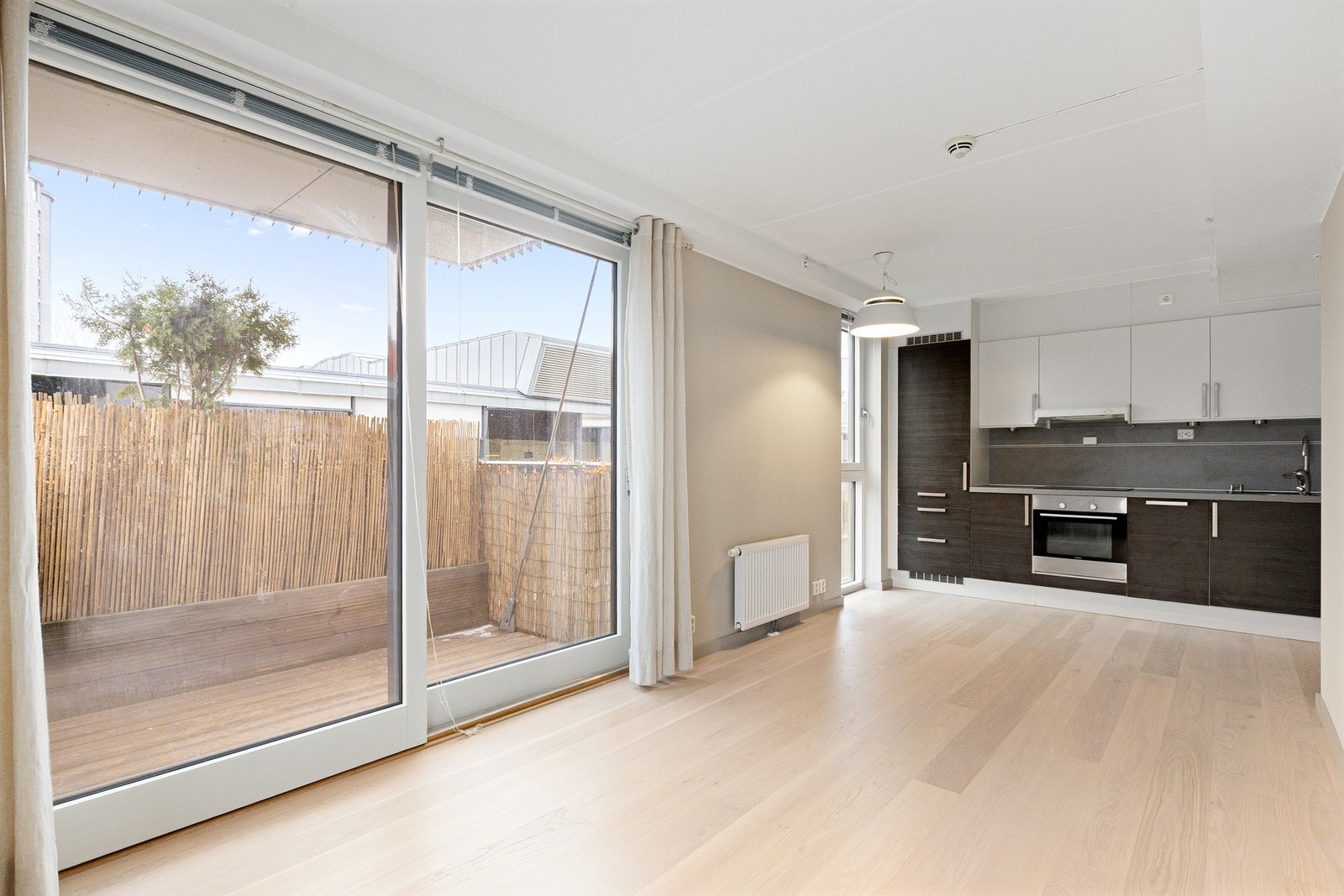 Videre er stuen utstyrt med store vindusflater og åpen løsning mot kjøkkenet. Galleribilde