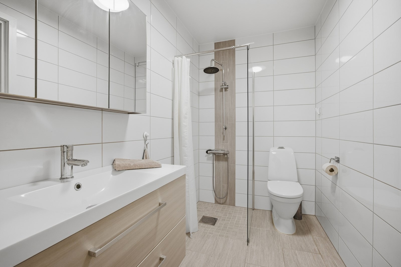 Helfliset bad på ca. 3,9 m². I henhold til tidligere salgsprospekt ble badet overflateoppusset i 2017 med nye fliser på gulv og vegger, nye gipsvegger og membran, samt ny dusj, toalett og baderomsinnredning. Galleribilde