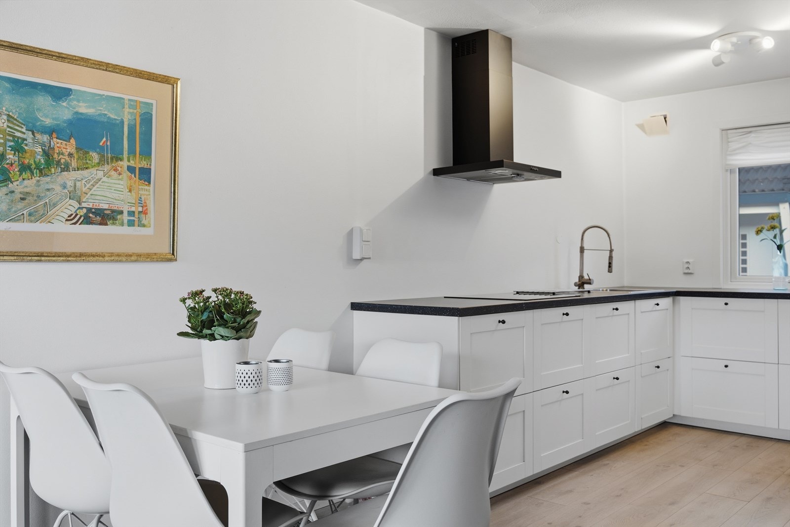 Kjøkkenet er utformet med hvit innredning og mørk laminatbenkeplate, samt integrerte hvitevarer bestående av stekeovn, induksjonstopp, oppvaskmaskin og kjøleskap med frysedel. Galleribilde