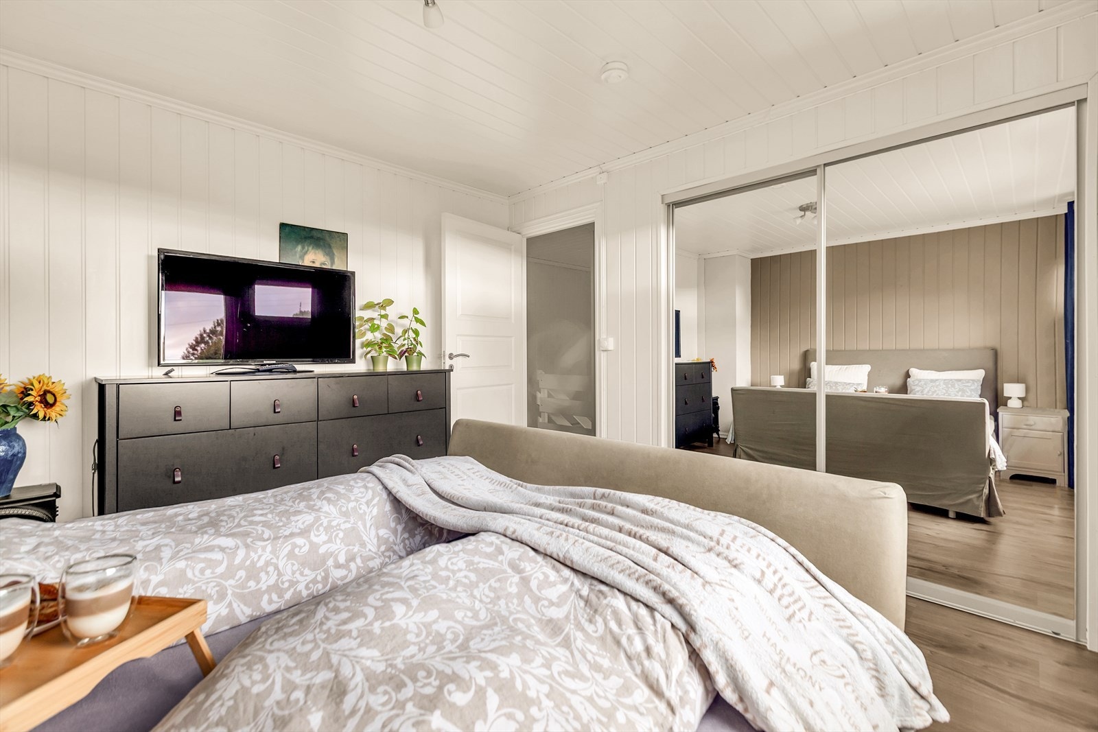 Videre er det plass til klesoppbevaring i romslig skyvedørsgarderobe med speilfronter. Galleribilde