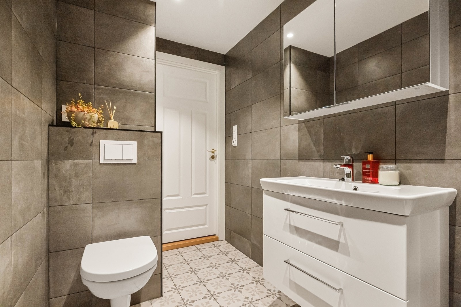 Lekkert bad fra 2022 med store fliser og stilren innredning med stramme linjer. Galleribilde