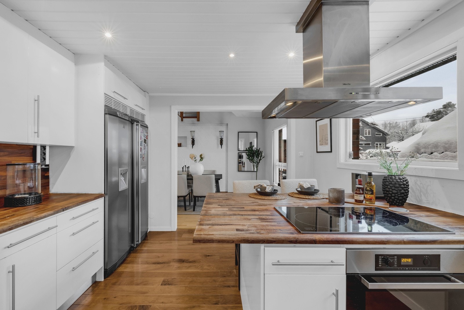 Kjøkkenet har innredning med glatte fronter. Benkeplaten er av heltre, kjøkkenventilator har avtrekk ut. Galleribilde