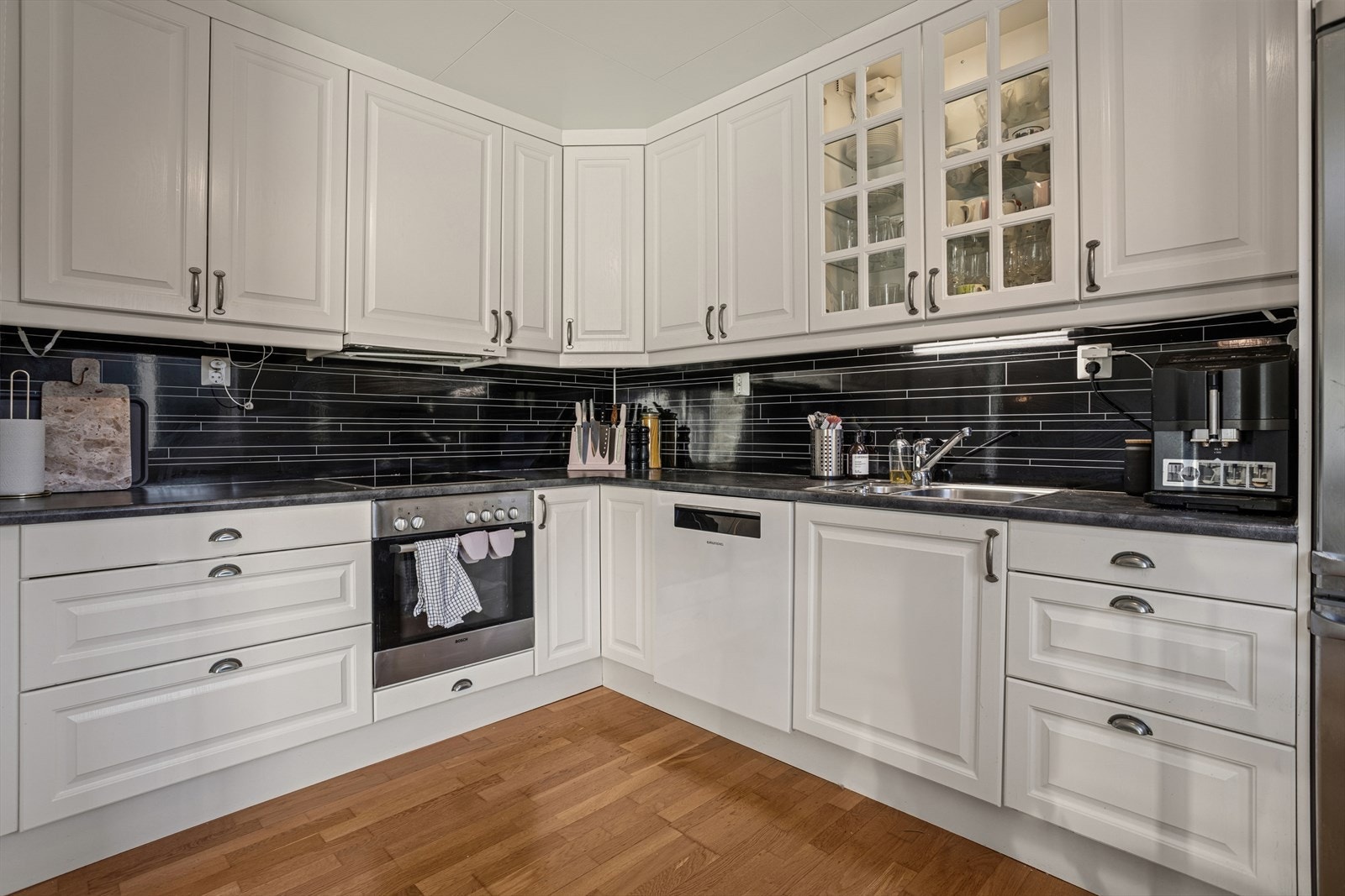 Stilren kjøkkeninnredning med profilerte fronter, laminat benkeplater og integrerte hvitevarer Galleribilde