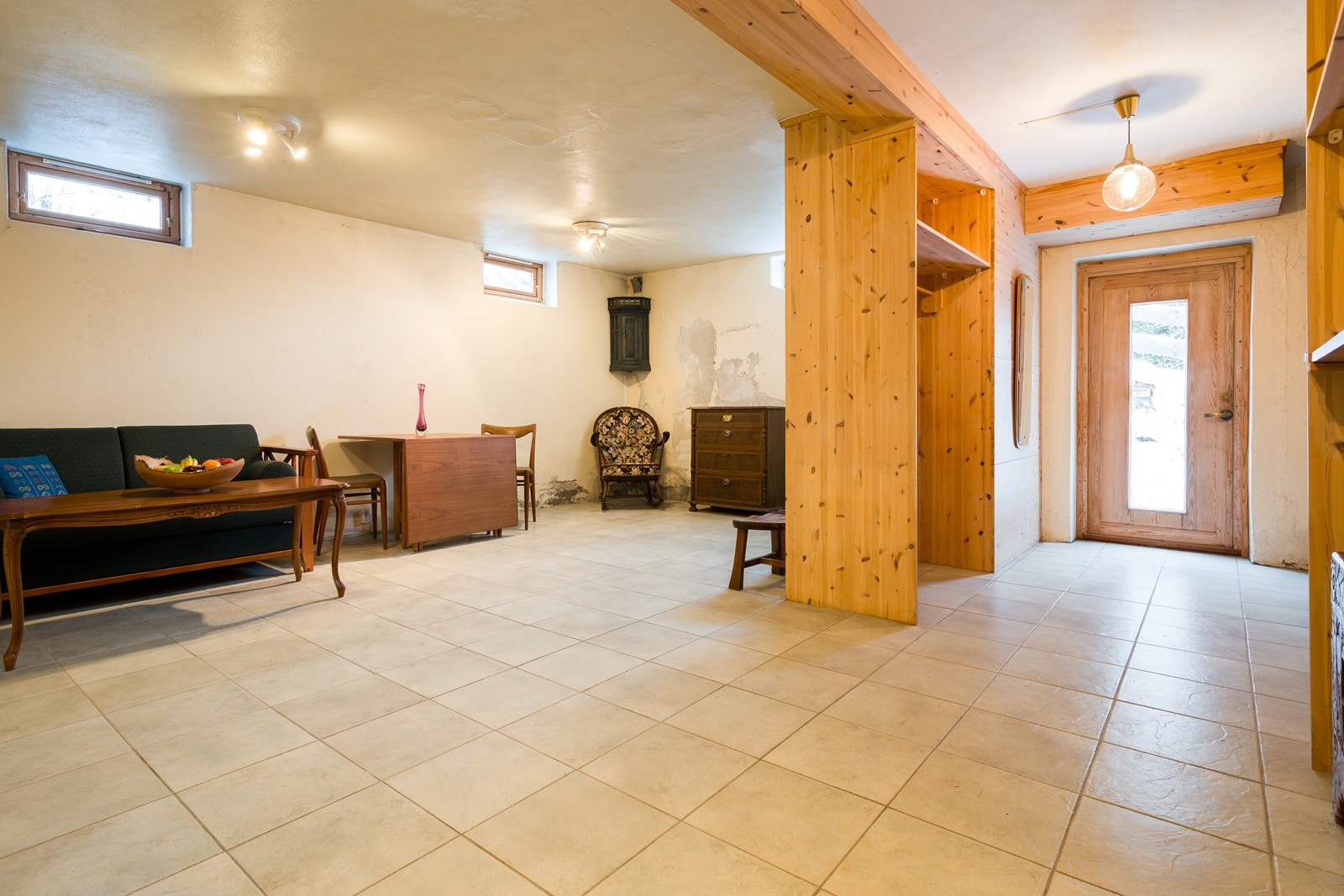 Flislagt gulv gir en praktisk og slitesterk overflate. Rommet har et lite hybelkjøkken bak reolveggen. Galleribilde