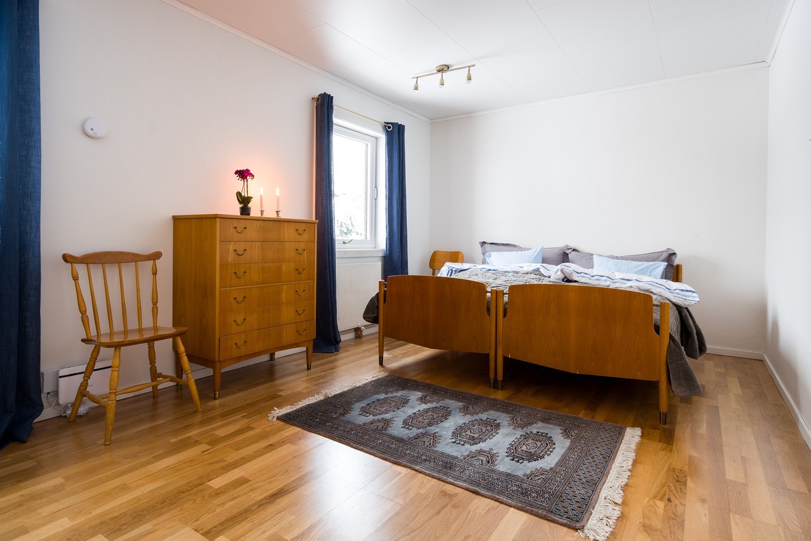 Parkettgulv gir rommet et varmt og innbydende preg, mens slette malte vegger gir en nøytral bakgrunn. Galleribilde