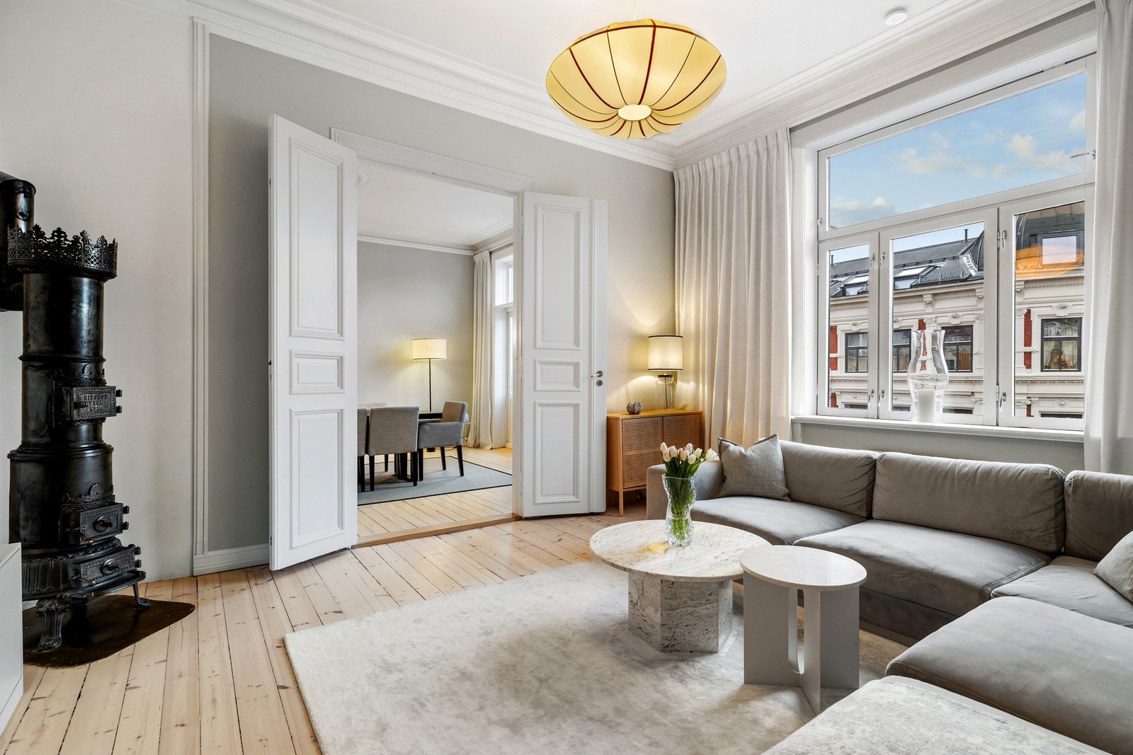 Rommet fremstår som lyst og luftig, med store vindusflater som slipper inn rikelig med naturlig lys gjennom hele dagen. Doble fløydører leder videre inn til spisestuen og skaper en sømløs og naturlig overgang mellom rommene. Galleribilde