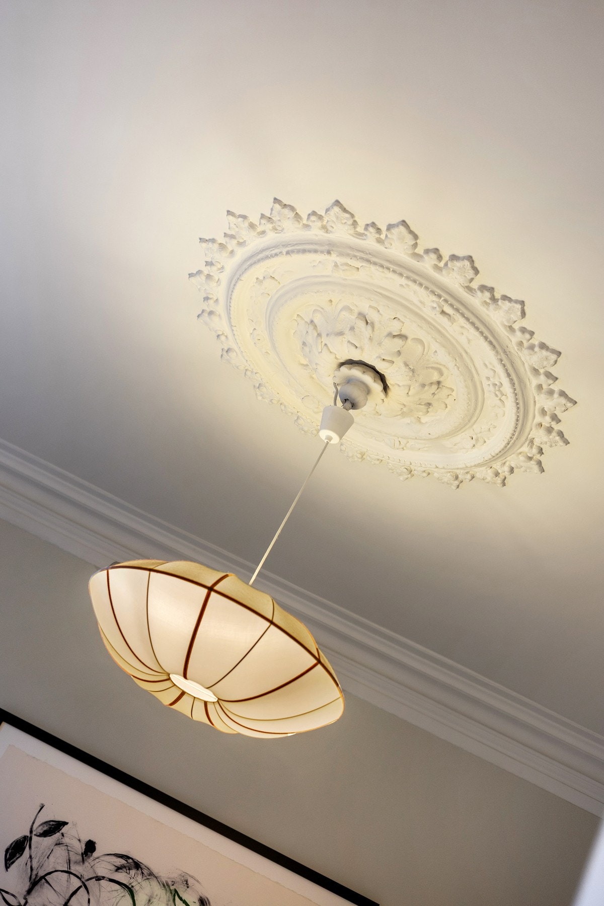 Klassiske detaljer som dekorativ takrosett understreker leilighetens tidstypiske uttrykk og gir stuen et eksklusivt preg Galleribilde