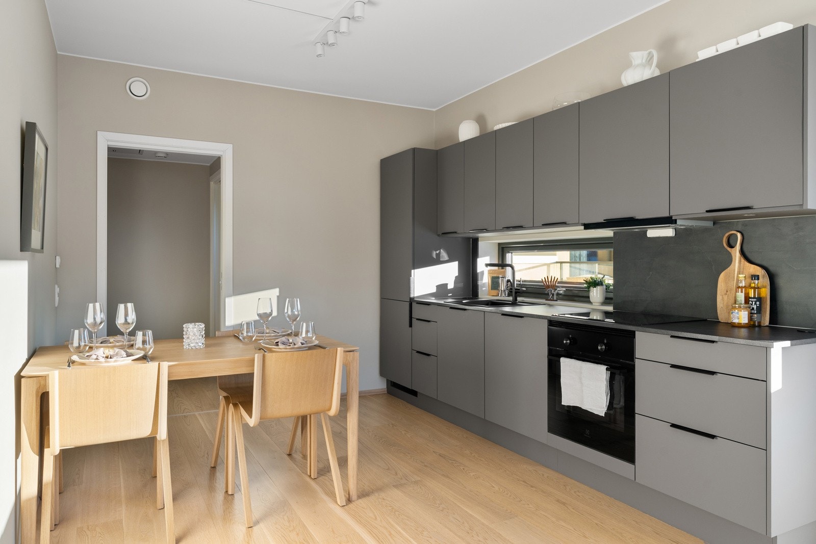 Moderne kjøkken fra HTH med laminatbenkeplate, sort nedfelt vask og dimbare spotter under overskapene. Galleribilde