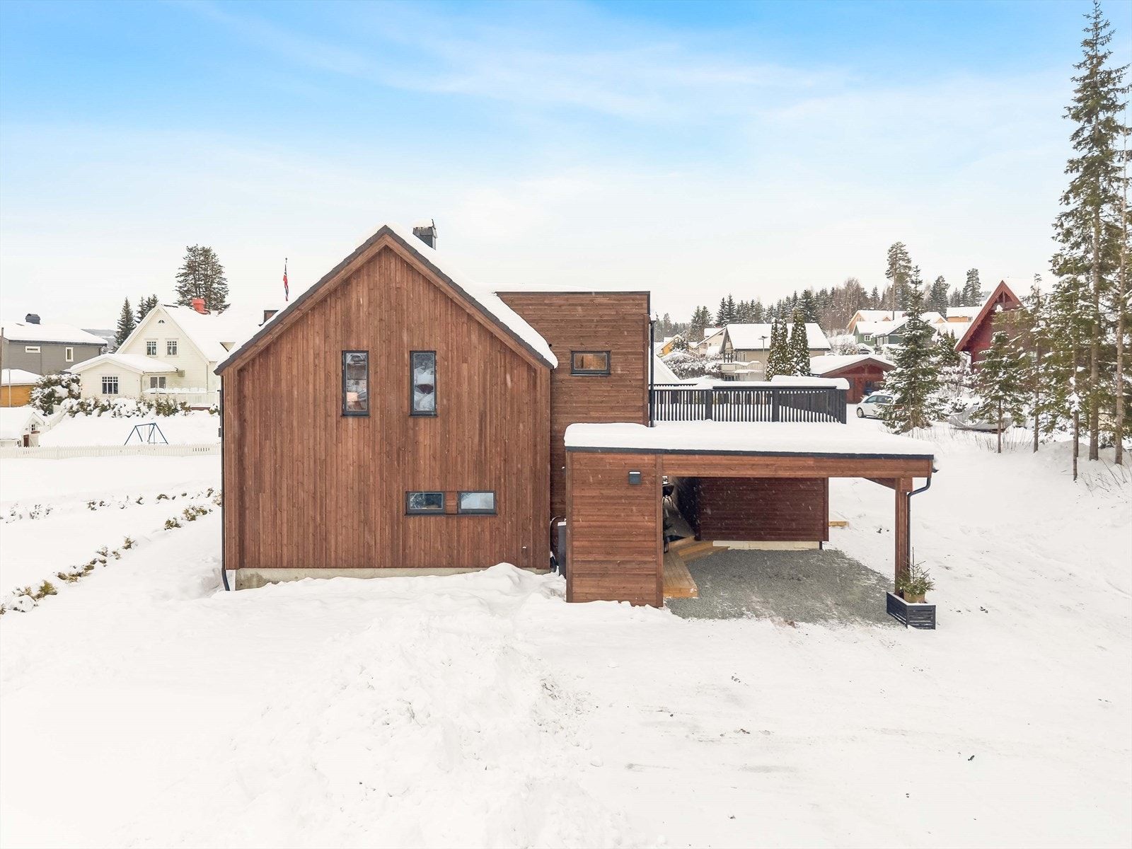 Gruset gårdsplass med enkel innkjøring til carport og inngangspari. Galleribilde