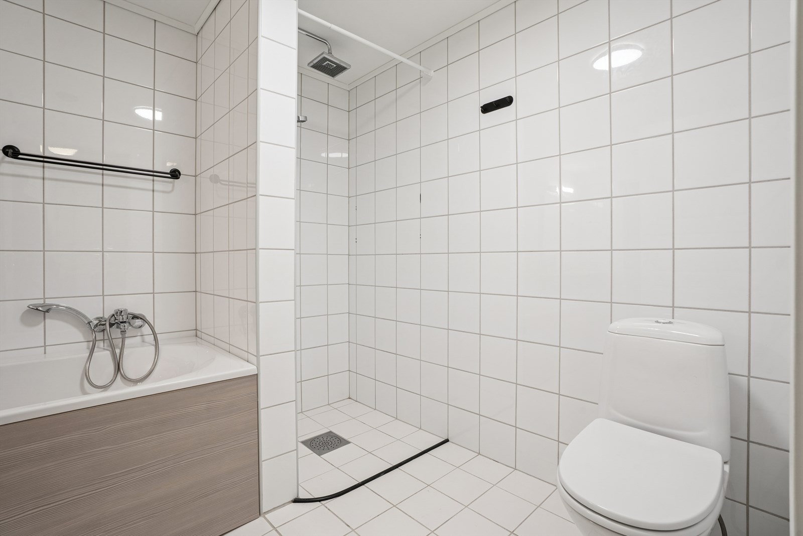 Lyst og fint bad med gjennomgående flislagte flater. Galleribilde