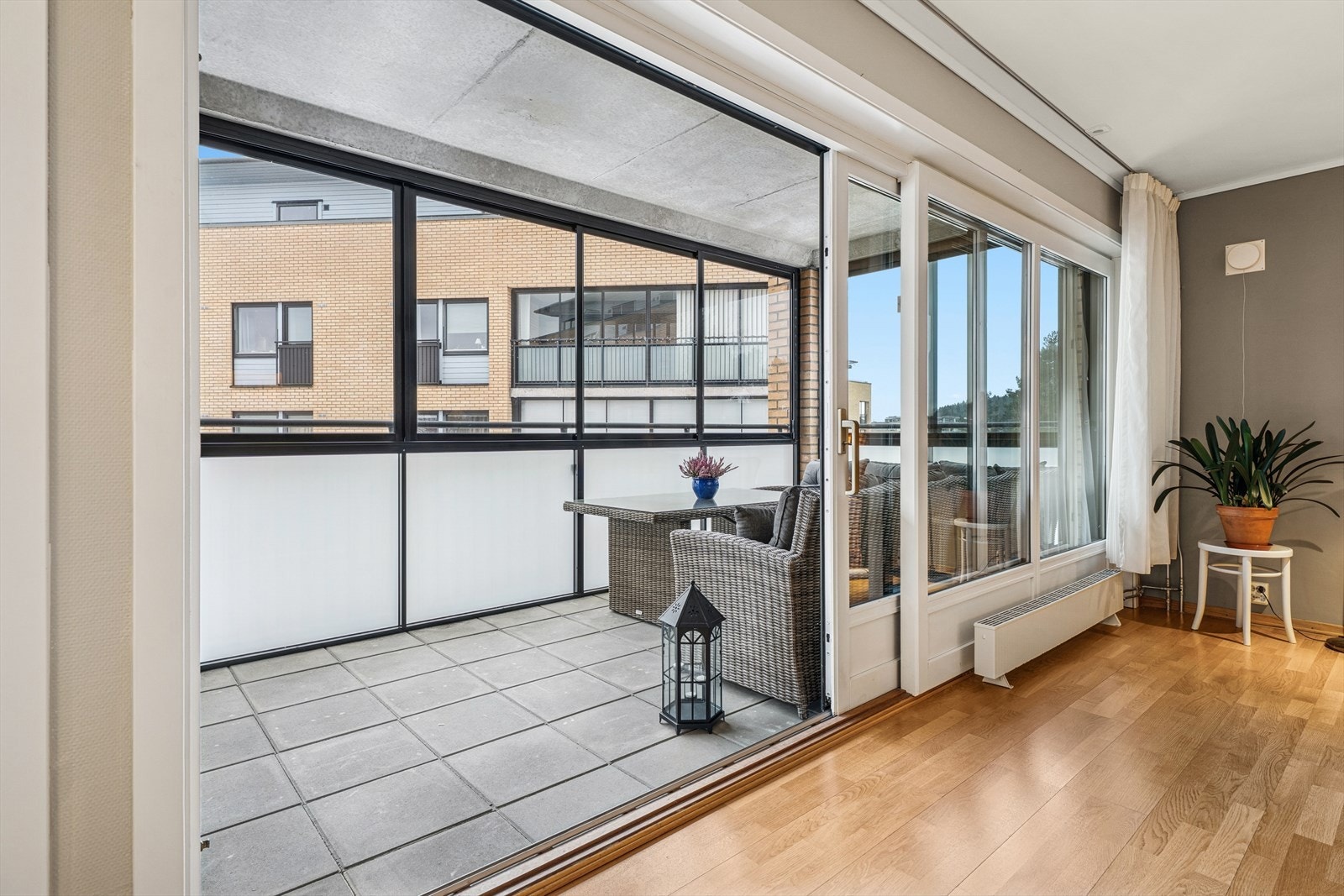 Stor skyvedør som lager en flytende overgang mellom stue og innglasset balkong. Galleribilde