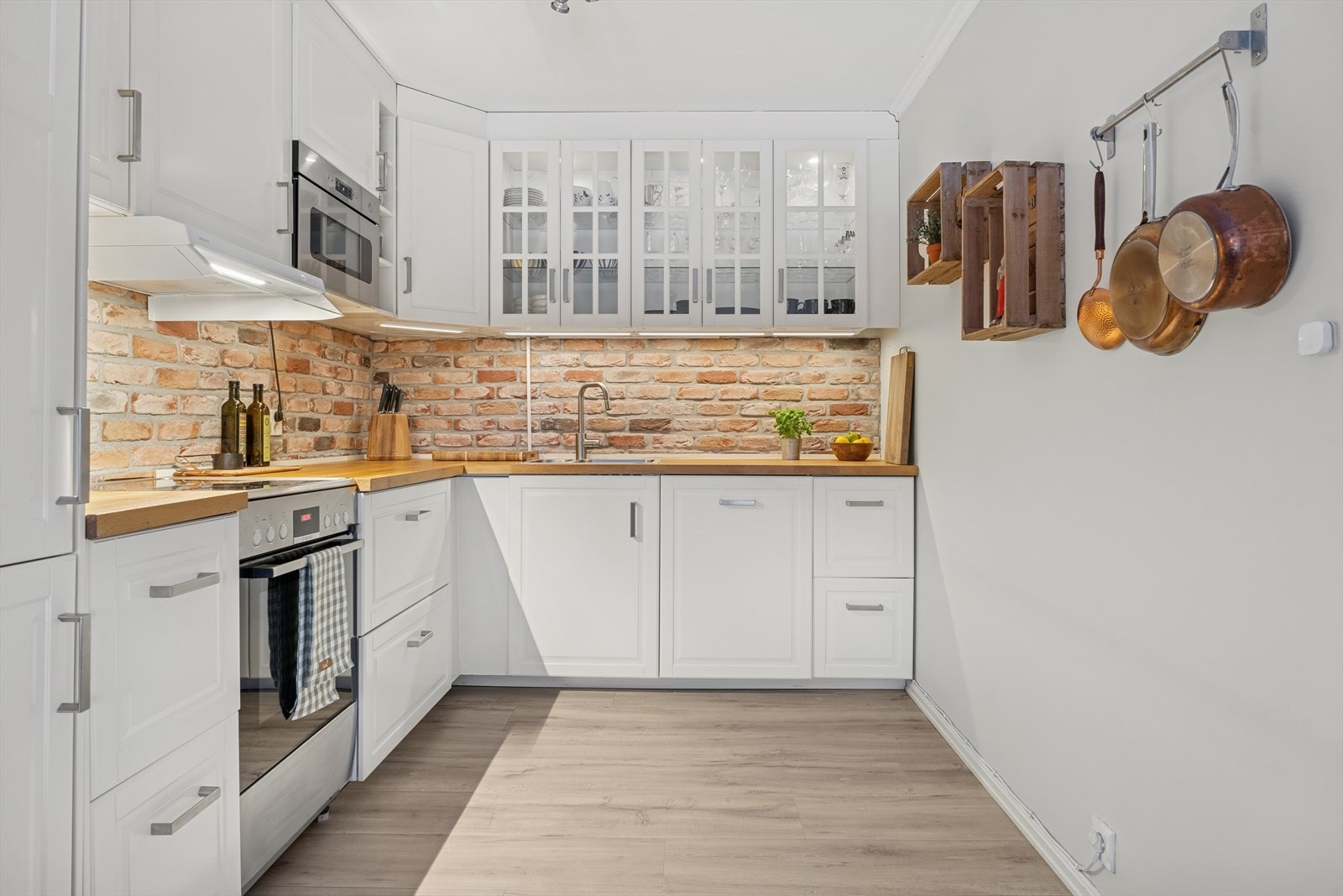 Innredningen har profilerte, lyse fronter og benkeplater i heltre med nedfelt oppvaskkum og blandebatteri. Galleribilde