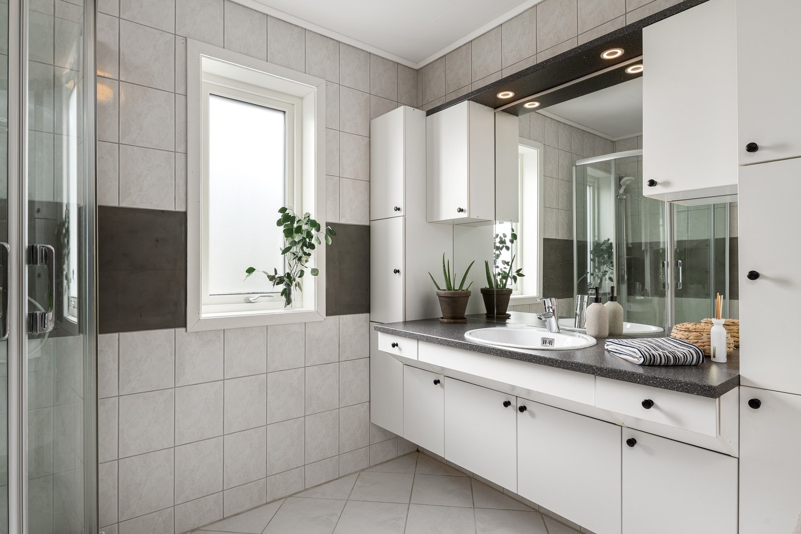 Videre er rommet utstyrt med dusj og toalett. Toalettrommet har fliser på gulv og er utstyrt med toalett og servant. Galleribilde