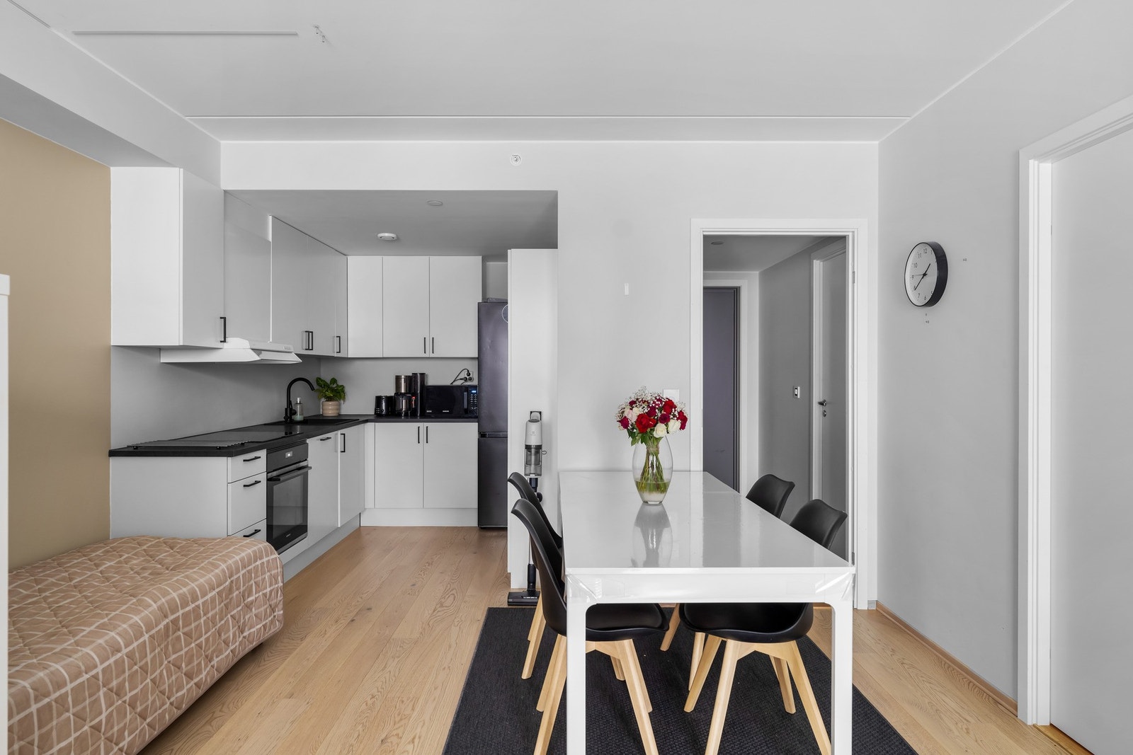 Stilrent og moderne kjøkken, nytt i 2024, utformet i funksjonell vinkelløsning med rikelig benke- og arbeidsplass. Innredning med hvite, slette fronter og laminert benkeplate i mørk utførelse med nedfelt oppvaskkum i sort kompositt. Galleribilde