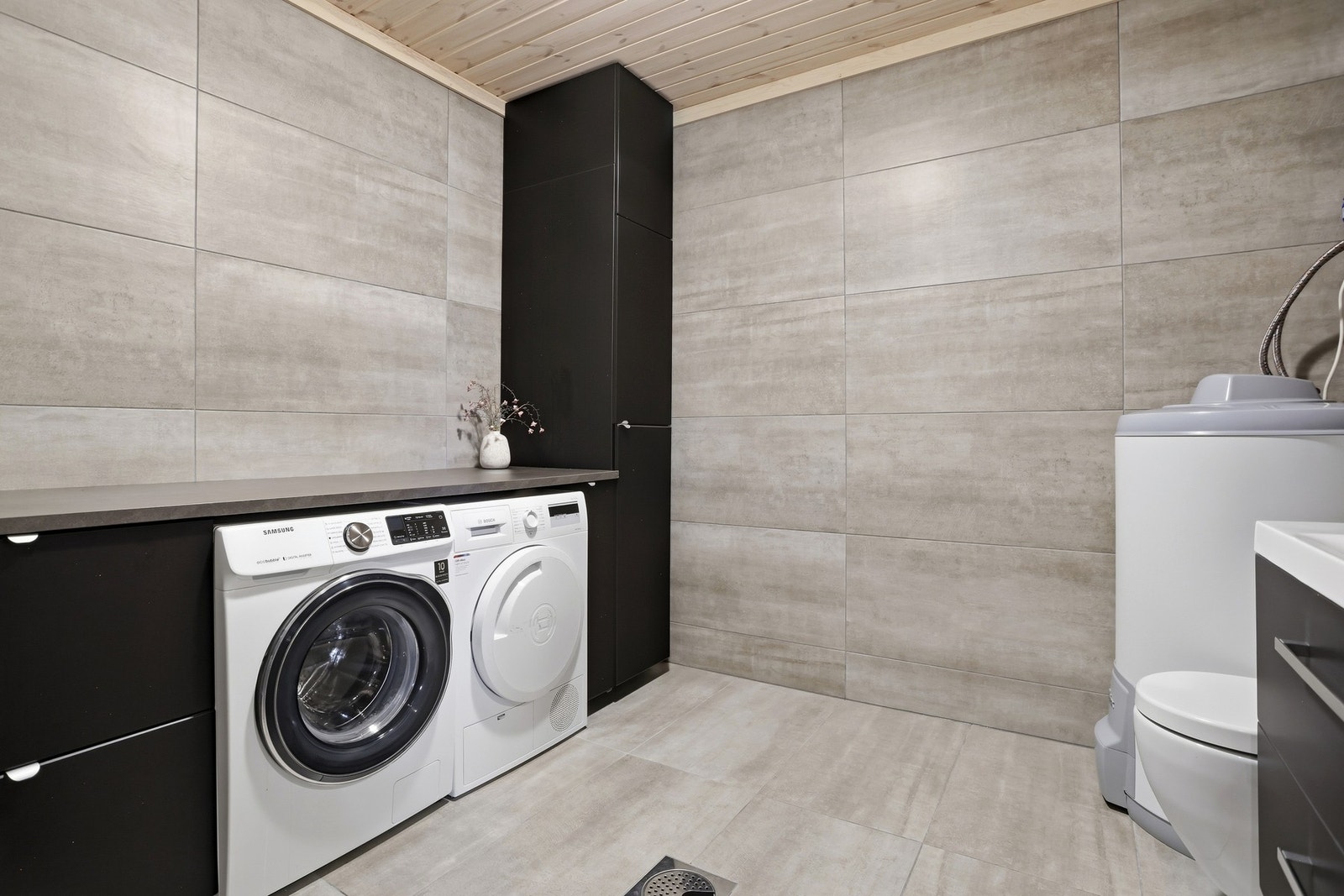 Vaskerom med toalett beliggende i underetasjen. Rommet er av god størrelse og har flott vaskeromsinnredning med plass til både vaskemaskin og tørketrommel Galleribilde