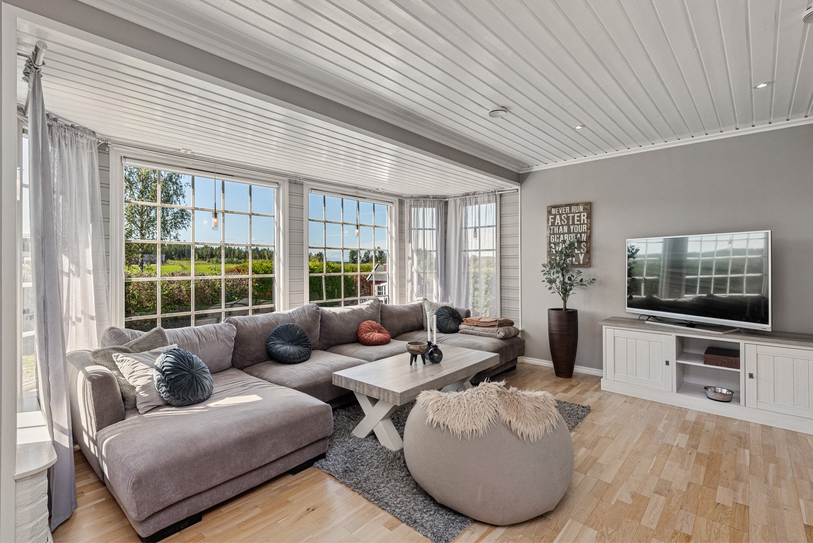 Mange store vinduer gir godt med naturlig lys inn i stuen Galleribilde