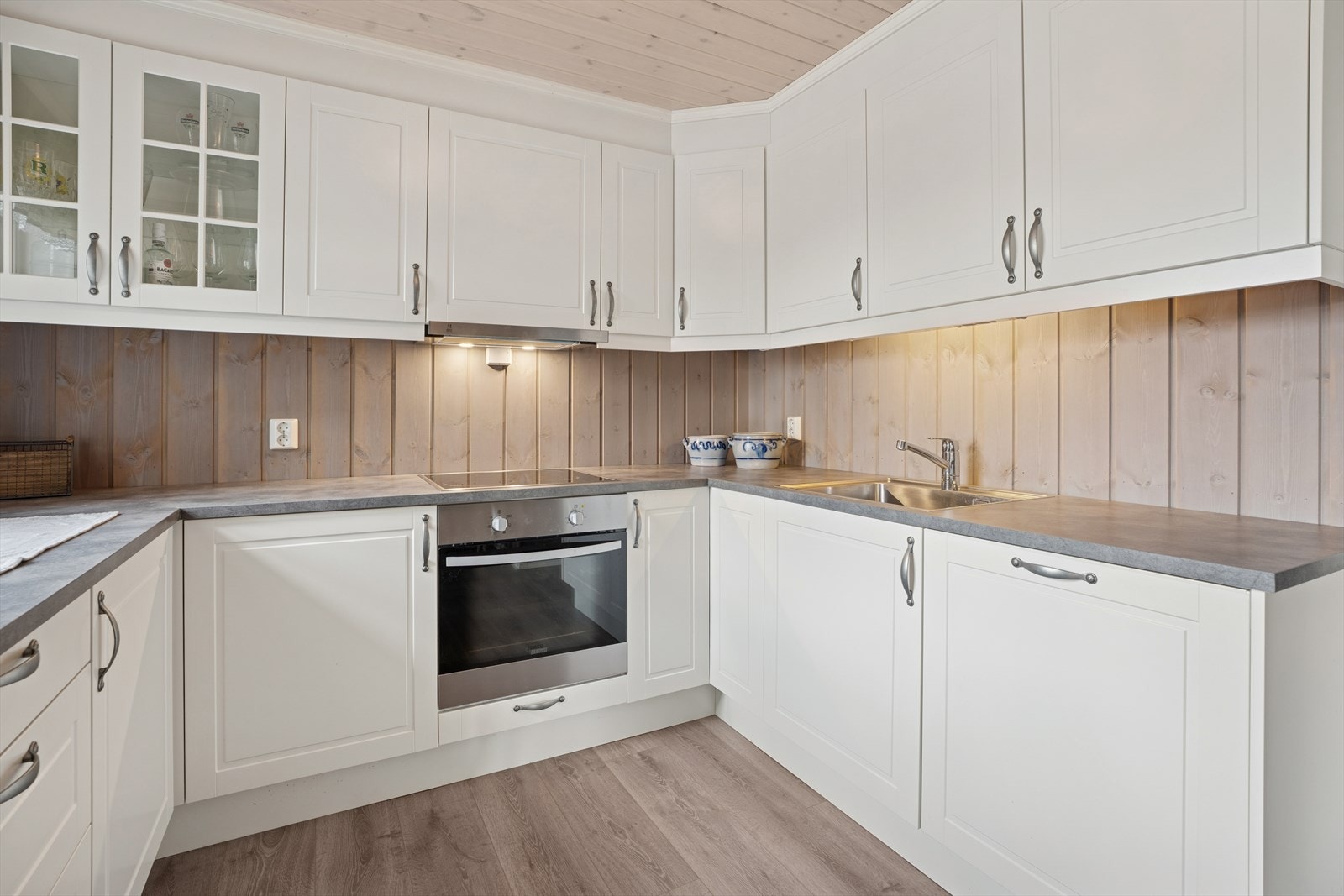 Pent Sigdal-kjøkken med malte, profilerte fronter på både over- og underskap. Enkelte overskap har vitrinedører som gir et lett og dekorativt uttrykk. Galleribilde