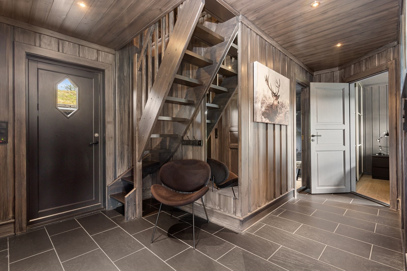 Praktisk flislagt entre med skyvedørsgarderobe og trapp til hems. Galleribilde