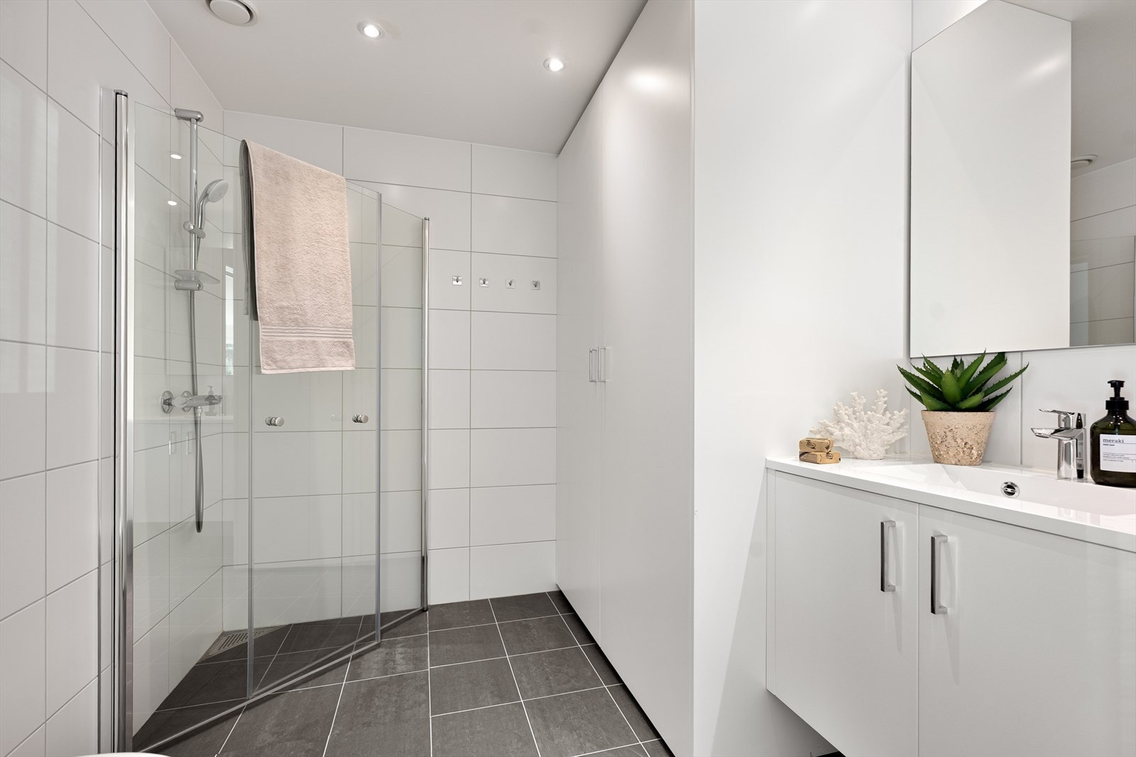 Sluket er diskret plassert i hjørnet av dusjen, noe som gir et rent og helhetlig uttrykk. Galleribilde