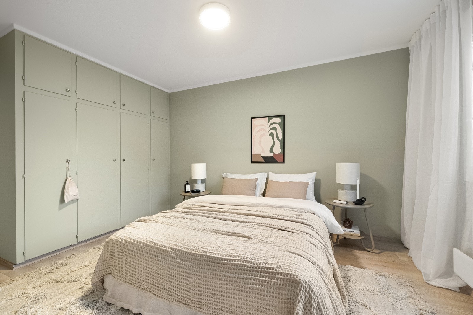 Romslig soverom med god plas til stor dobbeltseng med nattbord på hver side. Galleribilde