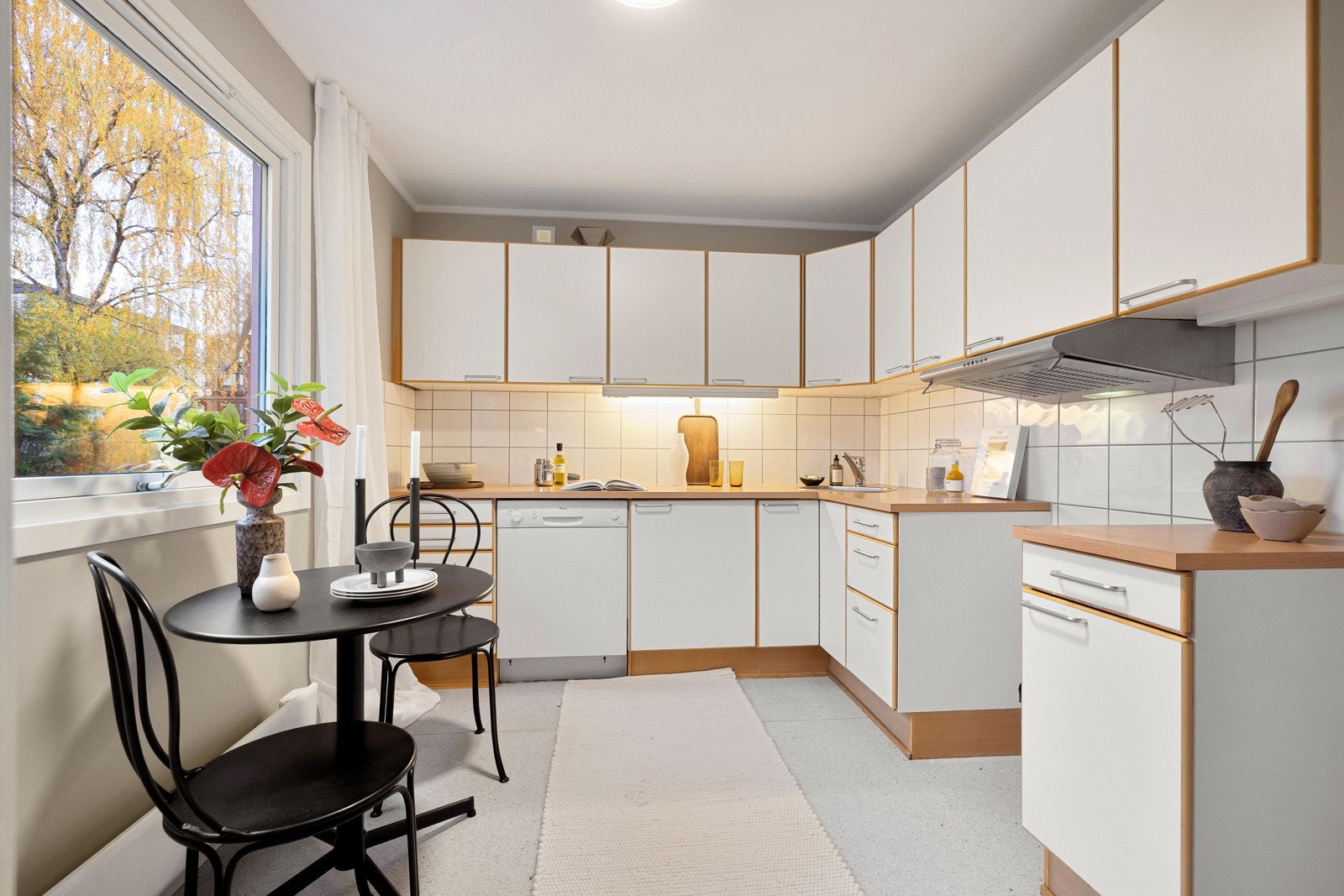 Kjøkkeninnredning med slette fronter og laminatbenkeplate med nedfelt vaskekum i børstet stål og ettgreps blandebatteri. Galleribilde