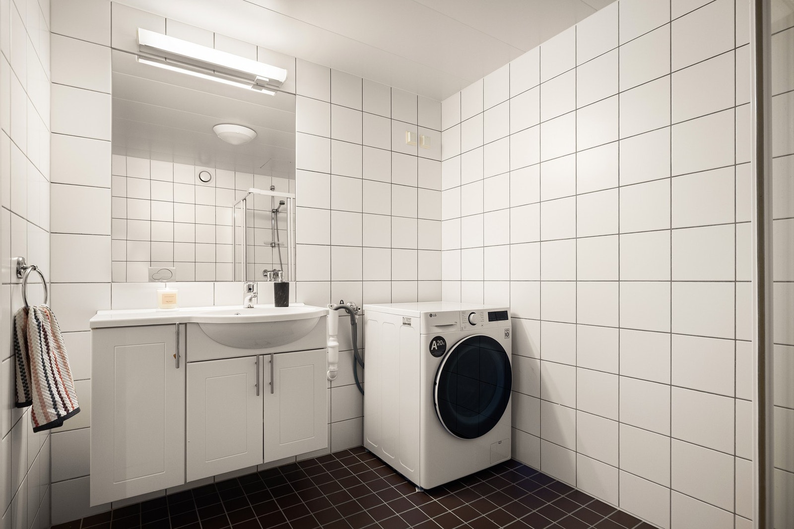 Leiligheten har et lyst og tidløst flislagt baderom fra 2005, med mørke gulvfliser med gulvvarme og lyse veggfliser som skaper et rent og moderne uttrykk. Galleribilde