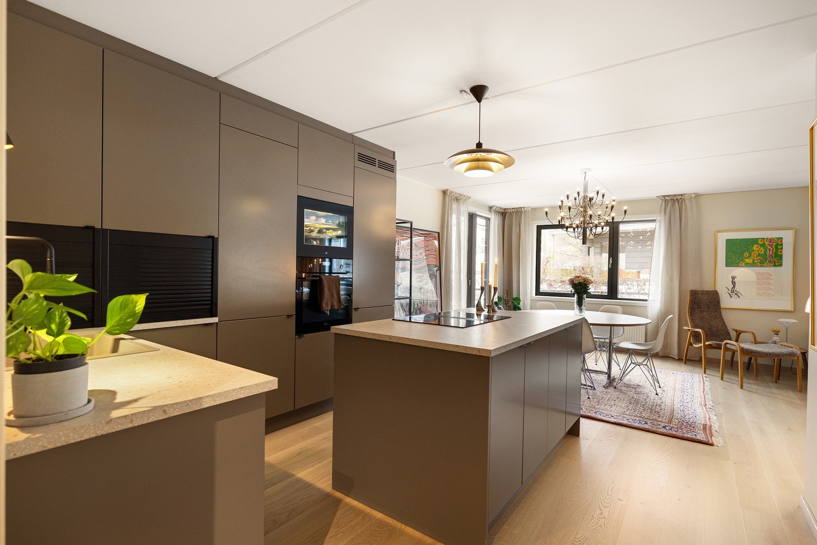 Innredningen preges av moderne, glatte fronter og en elegant backsplash som gir et tidløst uttrykk og gjør overflatene lettstelte. Galleribilde