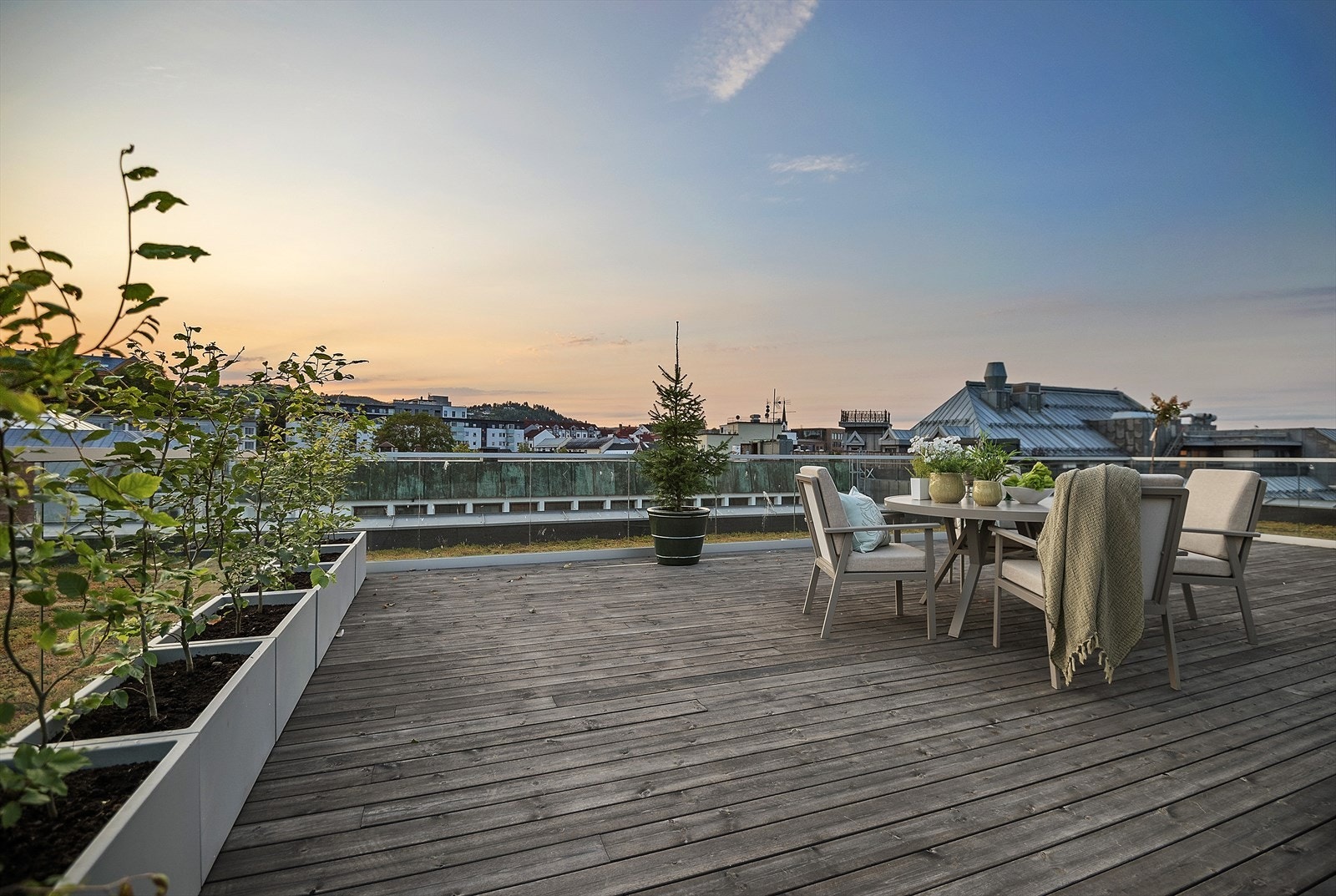 Kveldsstemning på takterrassen med utsikt mot byens tak. Galleribilde