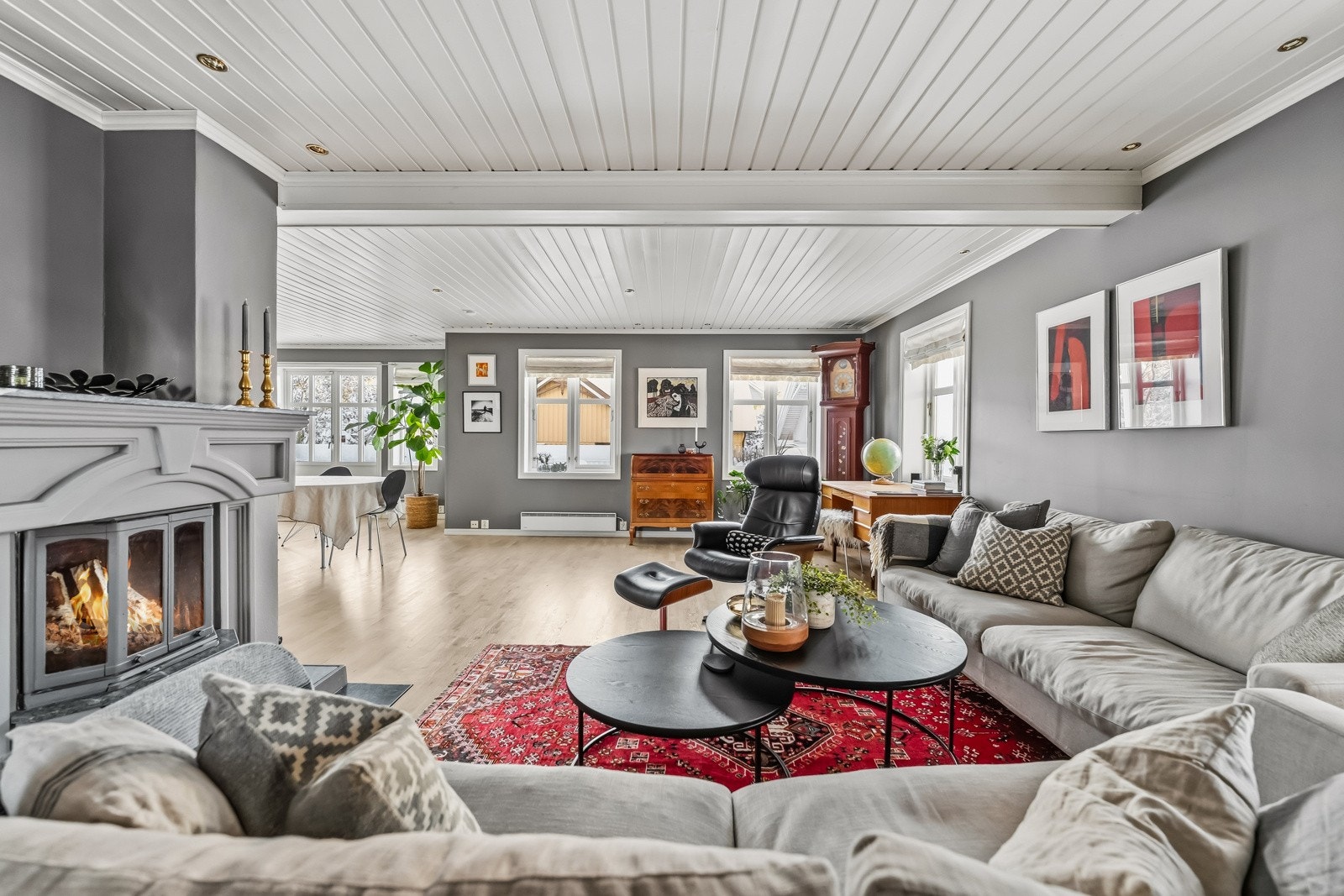 En peis i rommet gir ekstra hygge og en lun atmosfære på kalde dager. Rommet har store vindusflater som gir mye naturlig lys. Fra rommet er det dør ut til terrassen. Galleribilde