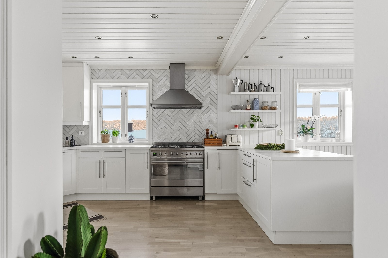 Kjøkkeninnredningen har fabrikkmalte fronter og malte benkeplater, og er utstyrt med ventilator, fliser over benk, belysning under overskap, elektrisk komfyr med gassbluss, integrert oppvaskmaskin og kjølehjørne. Galleribilde