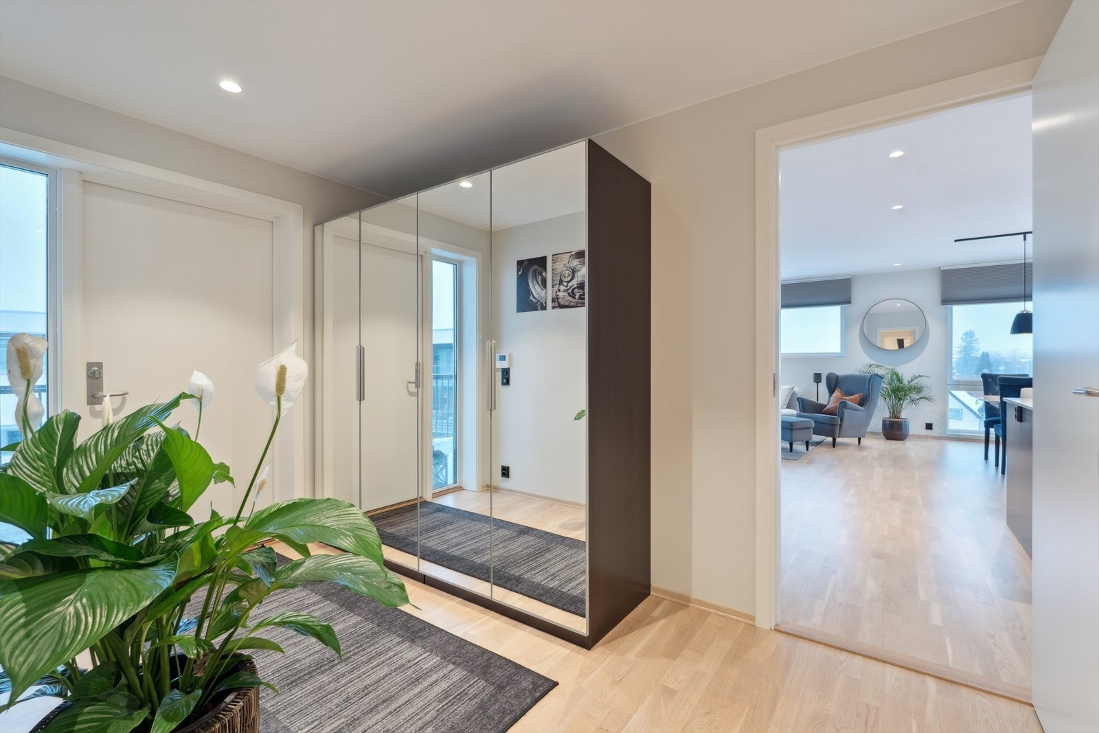 Man ønskes velkommen inn i en stor og lys gang som er praktisk innredet med garderobe som gir god lagringsplass for familiens klær og utstyr. Galleribilde