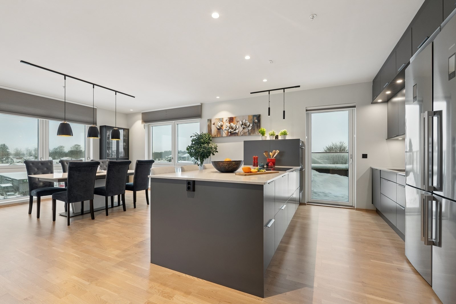 Kjøkkenet er hjertet i leiligheten og her er det ikke spart på noe som helst. Et stilrent og lekkert kjøkken innredet med grå, slette fronter og lys benkeplate i solid kompositt. Galleribilde