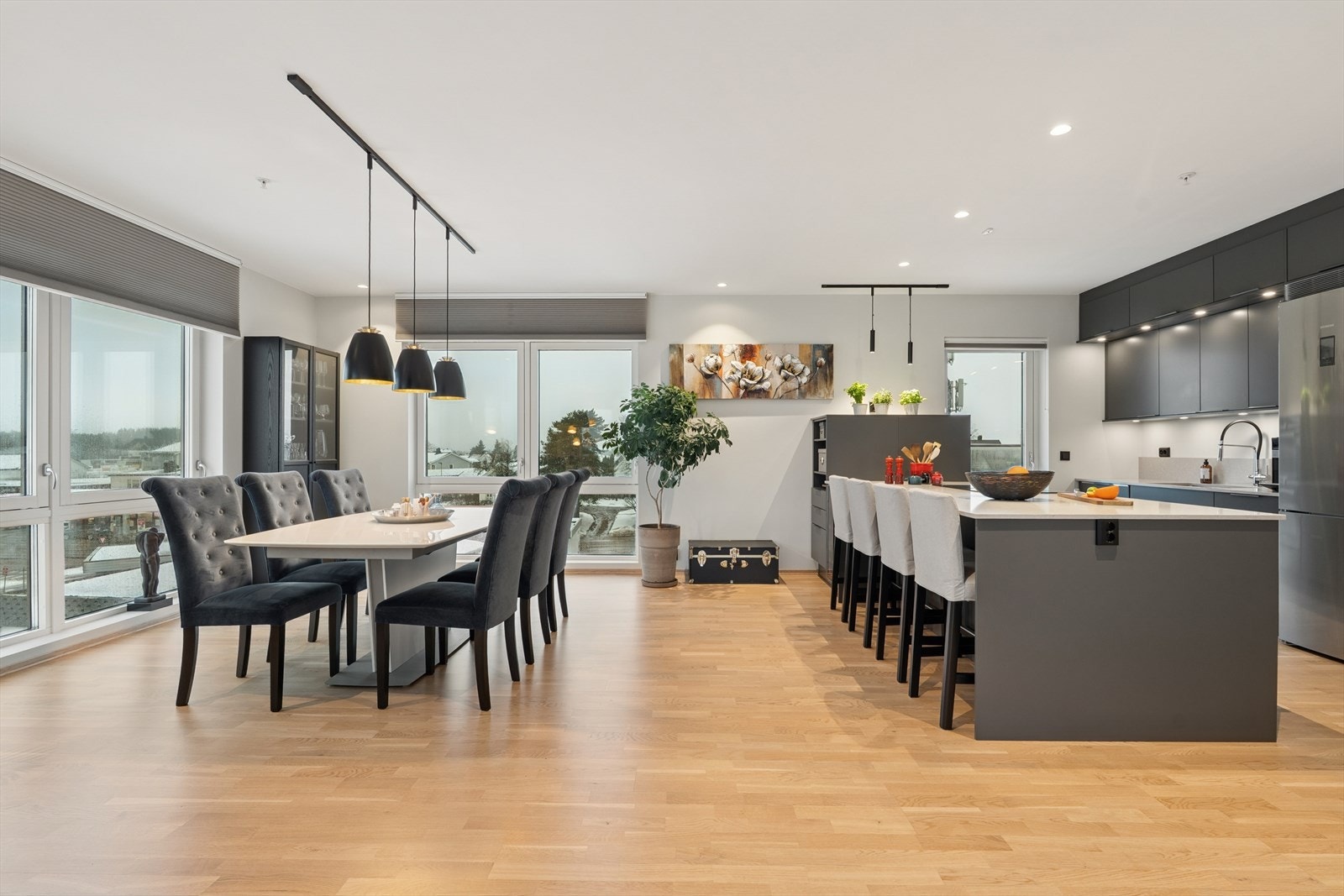 I stuen har man god plass til å dekke langbord til sosiale sammenkomster. I tillegg har man en stor kjøkkenøy med sitteplasser som bidrar til sosial matlagning. Galleribilde