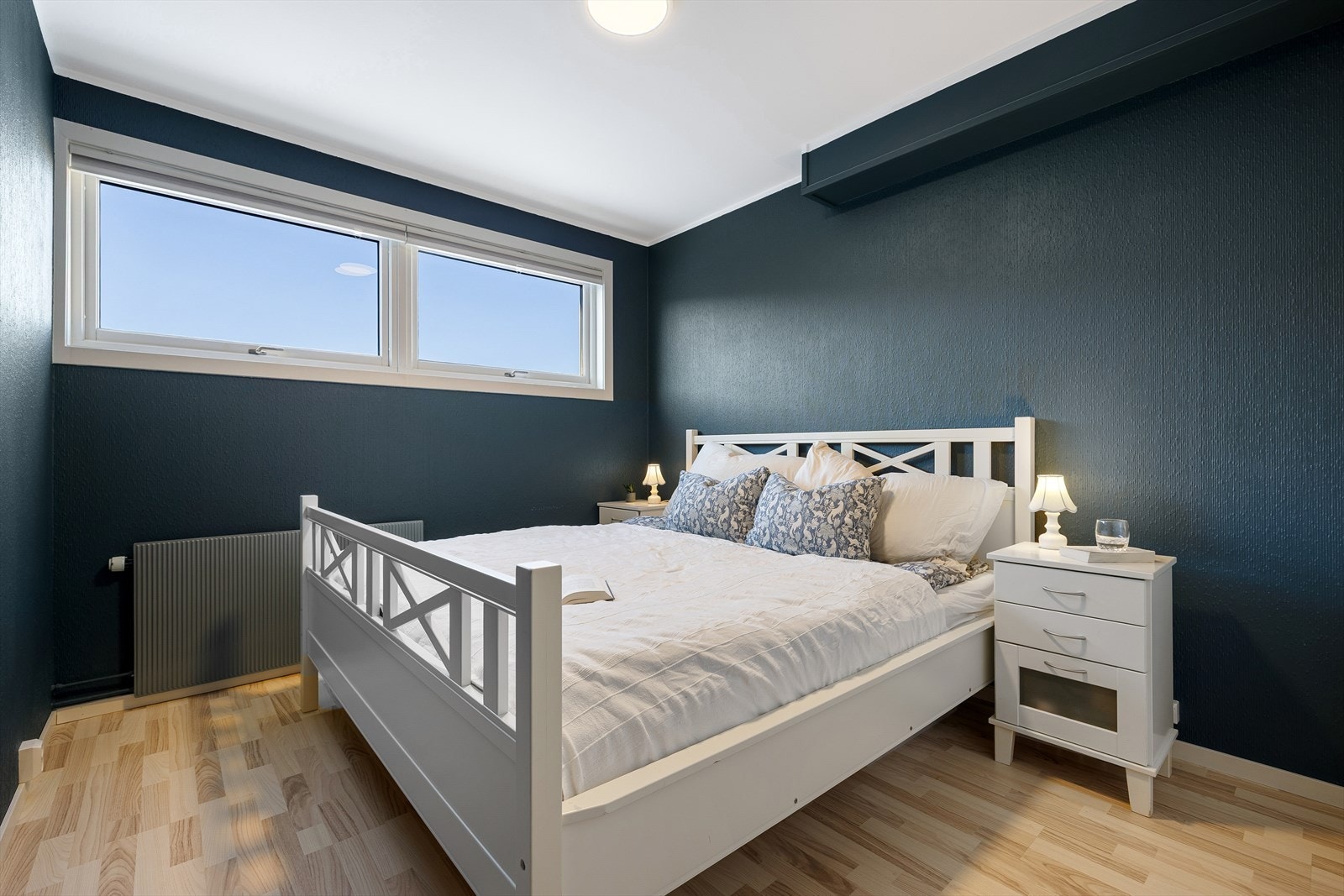 Soverommet er på hele 10 m² og er oppmalt i en blå og rolig fargetone. Rommet har vindusflater som slipper inn godt med naturlig dagslys på dagtid, og vender ut mot rolige omgivelser i boligfeltet. Galleribilde