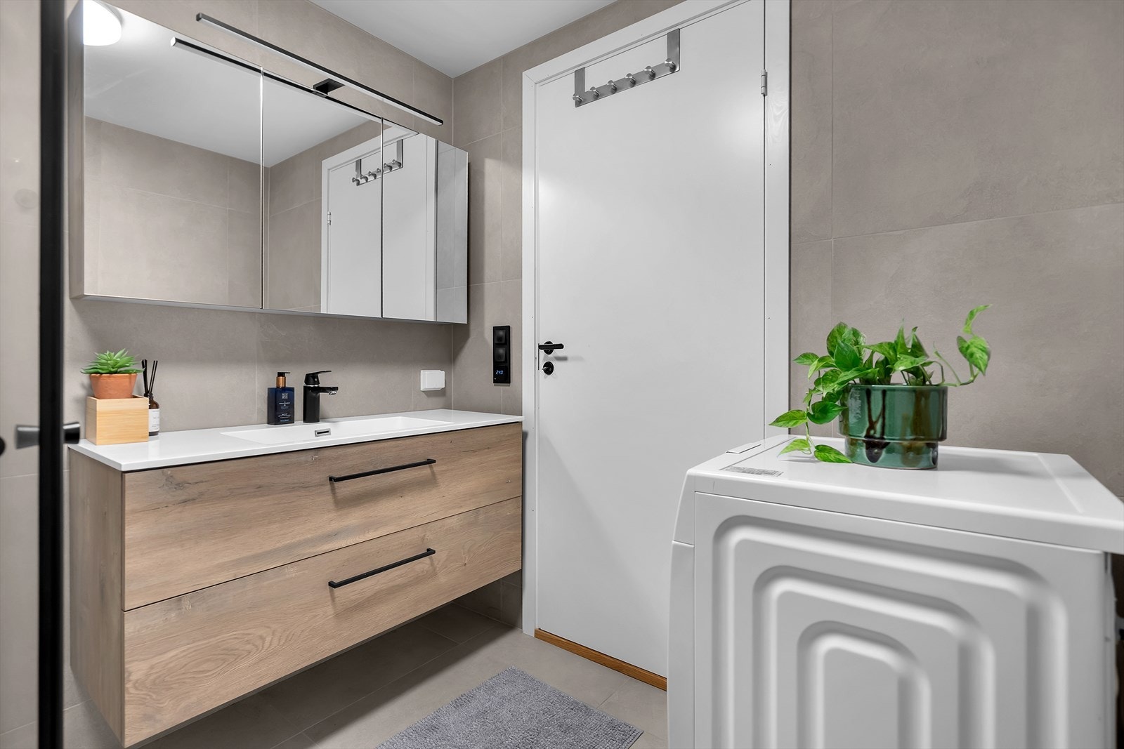 Videre finner du et speilskap, servant med underskuffer for praktisk oppbevaring, vegghengt toalett og opplegg for vaskemaskin. Gulvet er varmet opp med varmekabler for ekstra komfort, og mekanisk avtrekk sikrer godt inneklima. Galleribilde