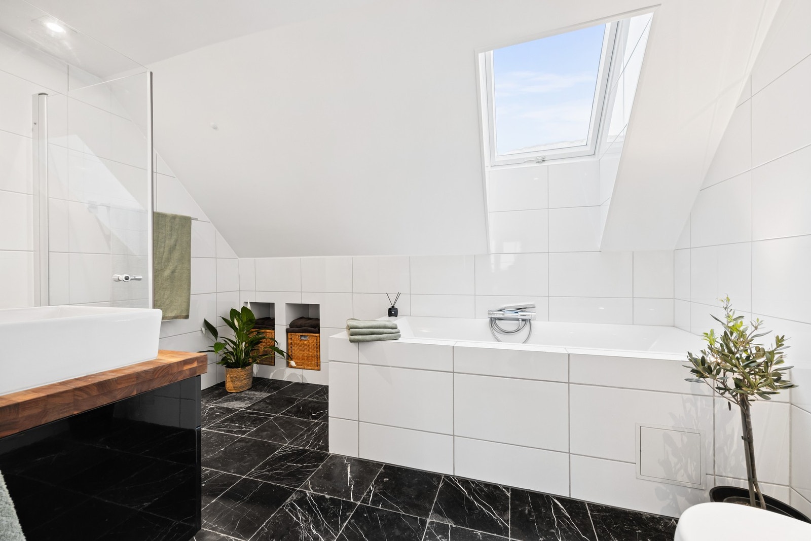 Bad i 2. etasje med innmurt badekar og dusjhørne med glassdører Galleribilde