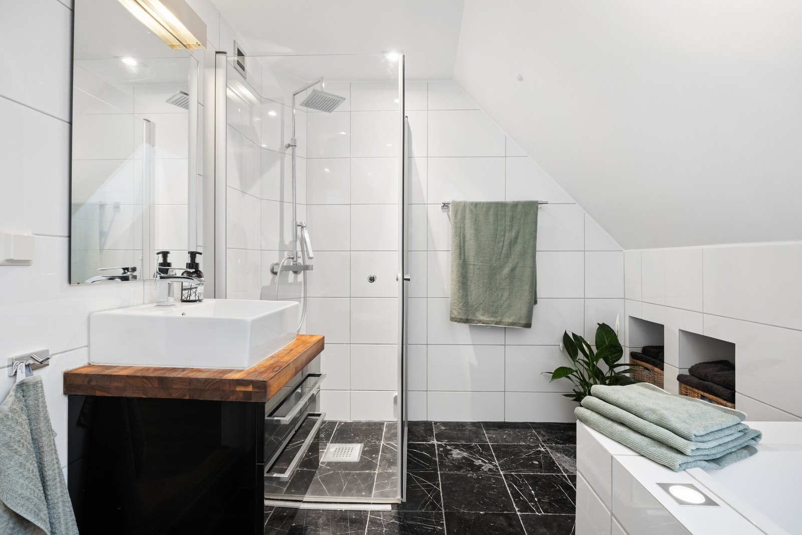 Bad i 2. etasje med innmurt badekar og dusjhørne med glassdører Galleribilde