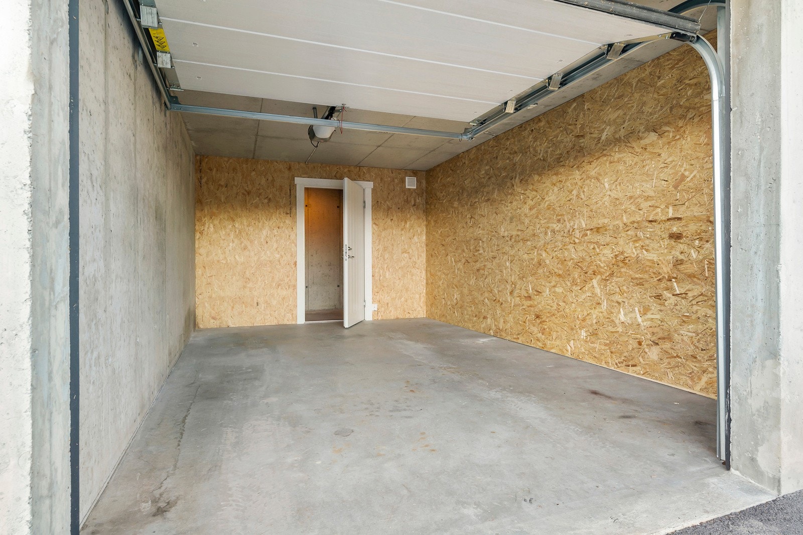 Garasjen har automatisk port og er adskilt mot naboen. I tillegg er det bod i bakkant. Galleribilde