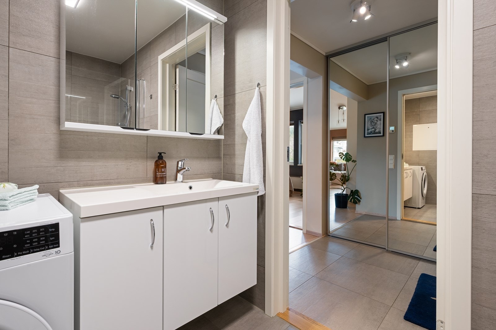 Baderommet fremstår som moderne med 60x60 fliser på gulv og vegger. Videre har badet behagelig gulvvarme og opplegg for vaskemaskin. Galleribilde