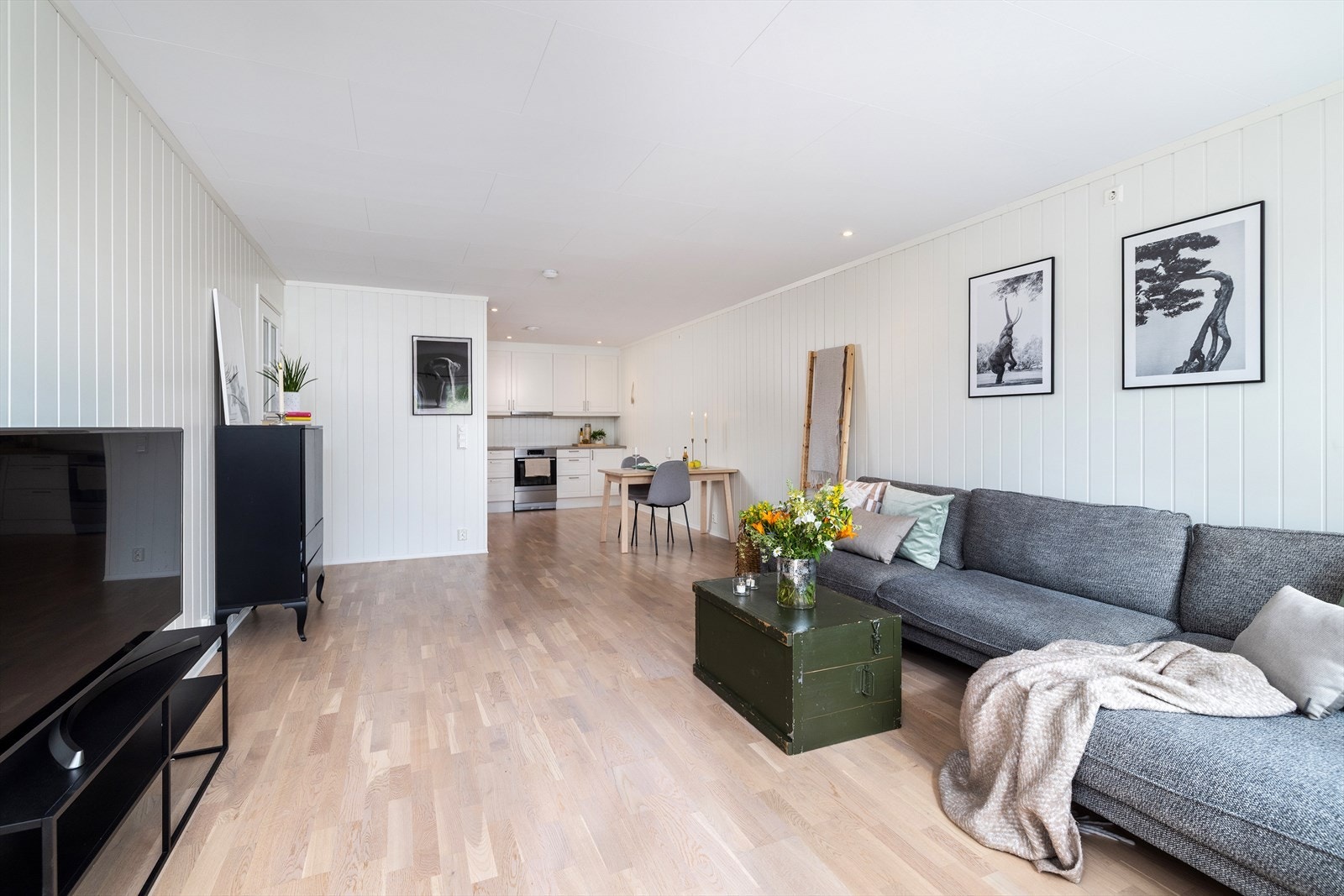 Stue har overflater med malte panelplater og parkett på gulvet. Galleribilde