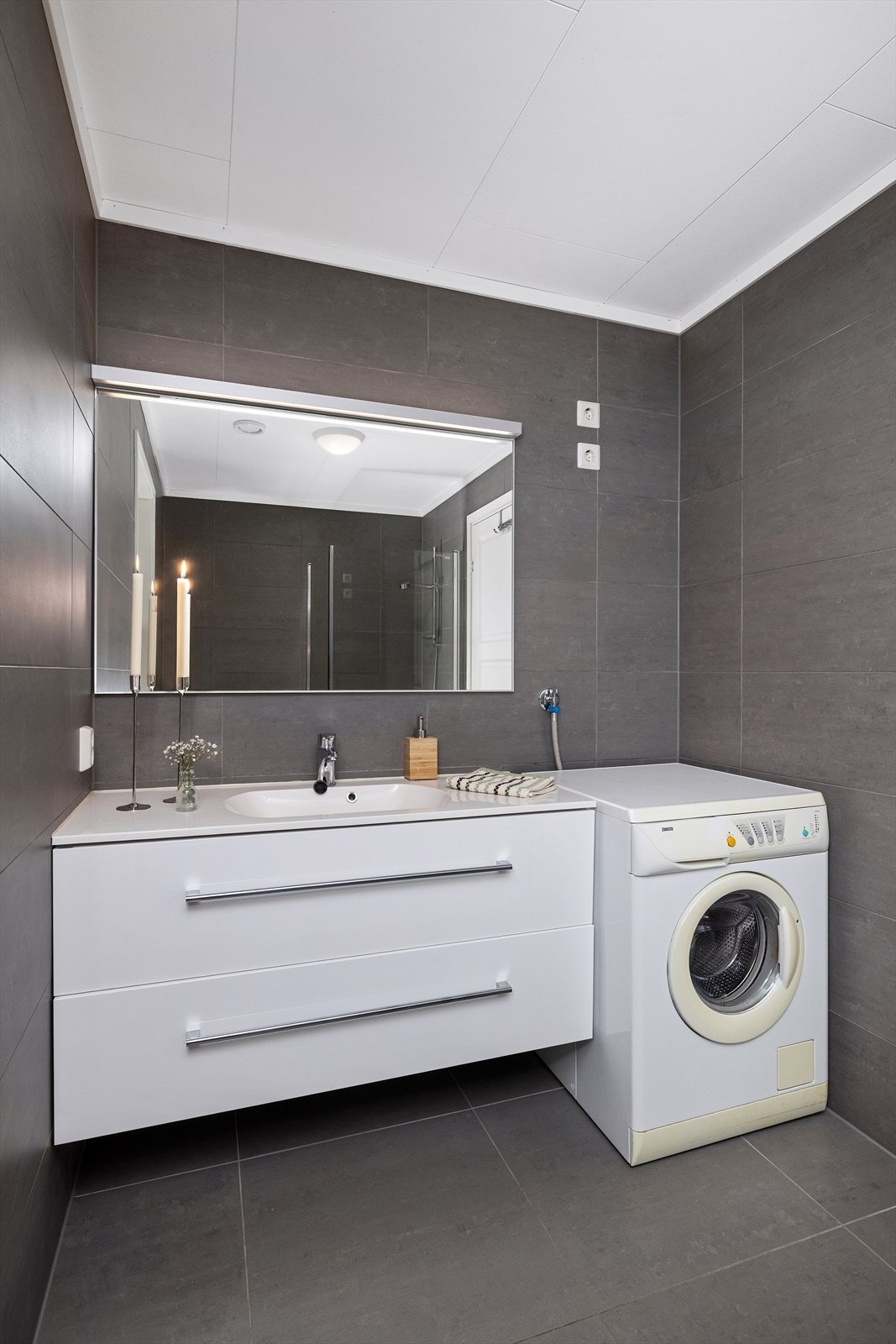 Her er det nedfelt servant med skuffer under og speil med lys armatur. Opplegg for vaskemaskin. Galleribilde